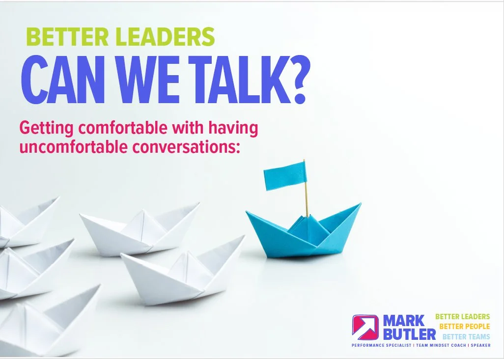 Several white paper boats and one blue paper boat with a small blue flag, symbolizing leadership and standing out from the crowd.