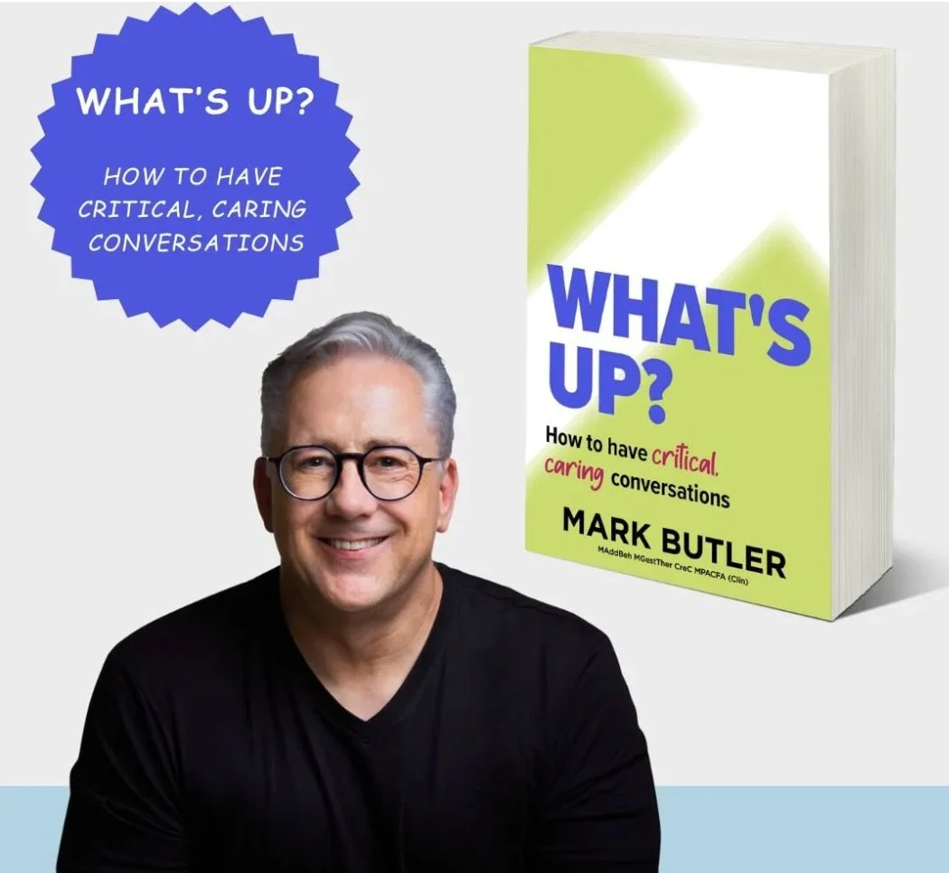 Cover of the book titled 'What's Up? How to have critical, caring conversations' by Mark Butler, with a smiling man wearing glasses in front of a light background.
