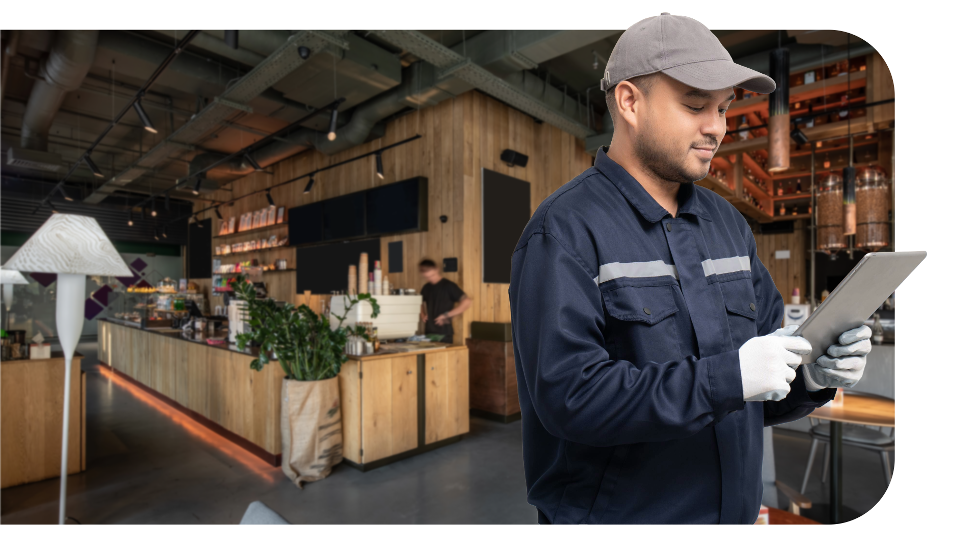 Tekniker med tablet og caps på og kafee i bakgrunn