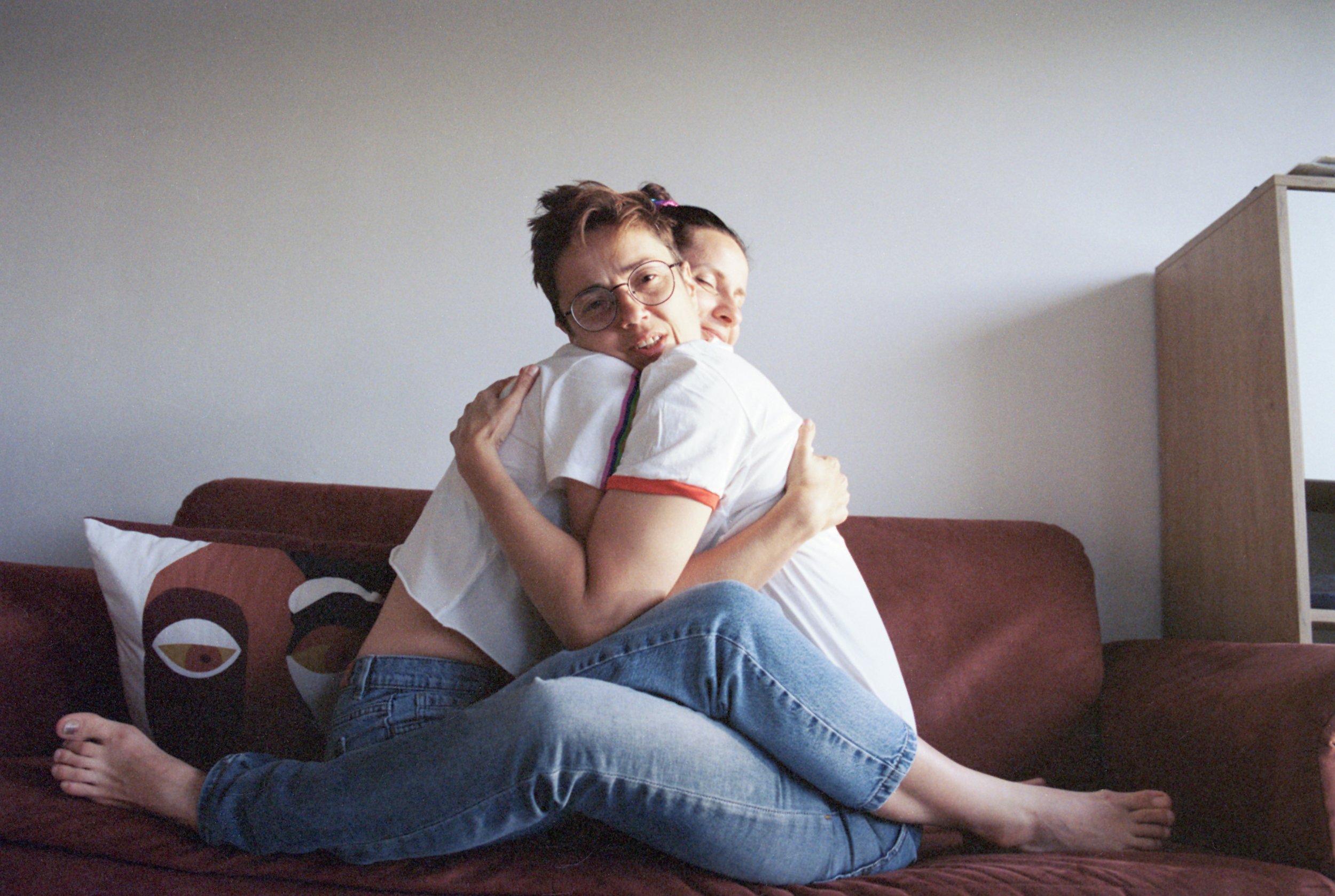 Olga and Nataly hugging on their couch, wearing their PRIDE t-shirts.
It took Nataly and her wife about a year to get used to being accepted. Not being scared to say, they were an LGTBQ family. When taking their daughter to school they are greeted b