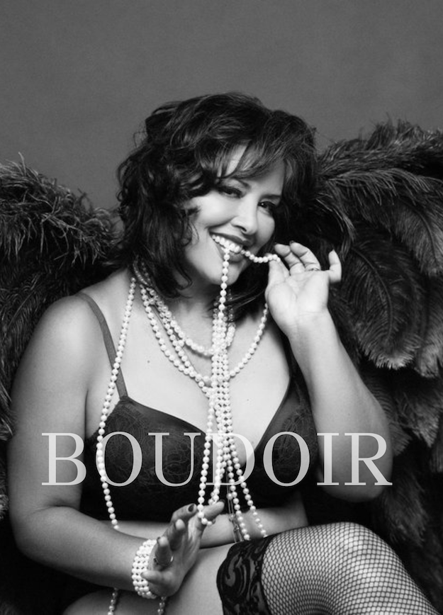 Connecticut headshots and branding photographer: Black and white photograph of a smiling woman wearing a lingerie top, fishnet stockings, and multiple pearl necklaces, sitting with feathered wings behind her, and the word 'BOURD' overlaid.