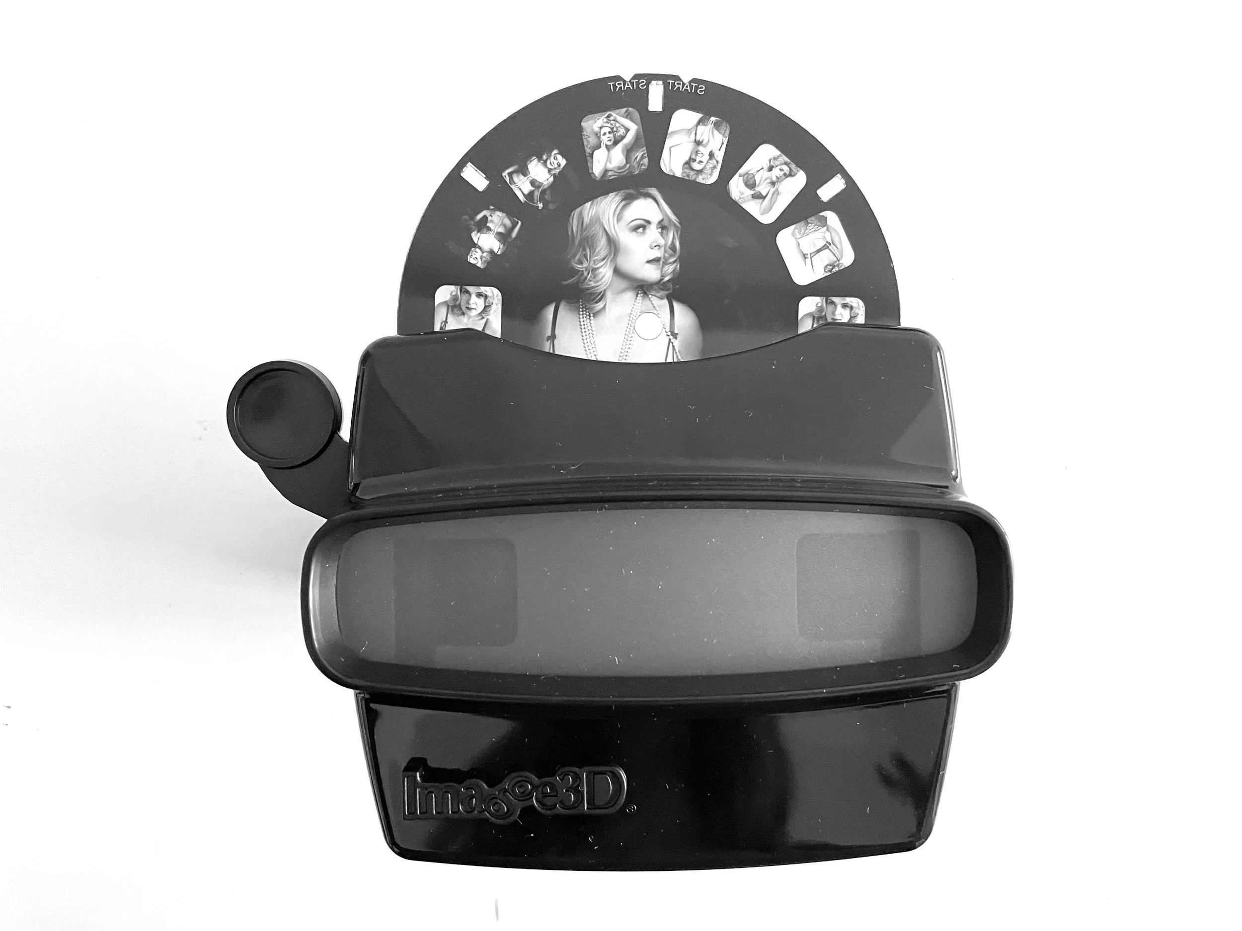 Black and white image of a vintage View-Master toy with a reel showing a woman with blonde hair in various poses.
