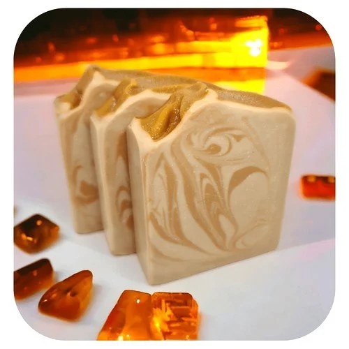Handmade Egyptian Amber soap with warm golden tones and resin pieces, featuring a creamy swirl design and rich amber backlighting
