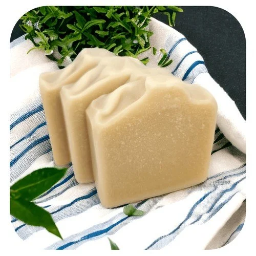 Handmade goat milk soap with no fragrance or colour, creamy natural bar on cloth with greenery