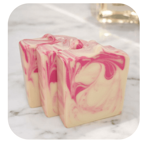 Handmade Saigon soap with pink and cream swirl on marble background