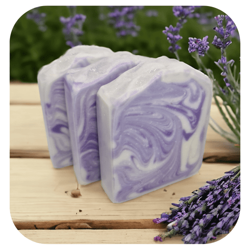Handmade French Lavender soap with soft purple swirl design, displayed on wooden surface with fresh lavender sprigs