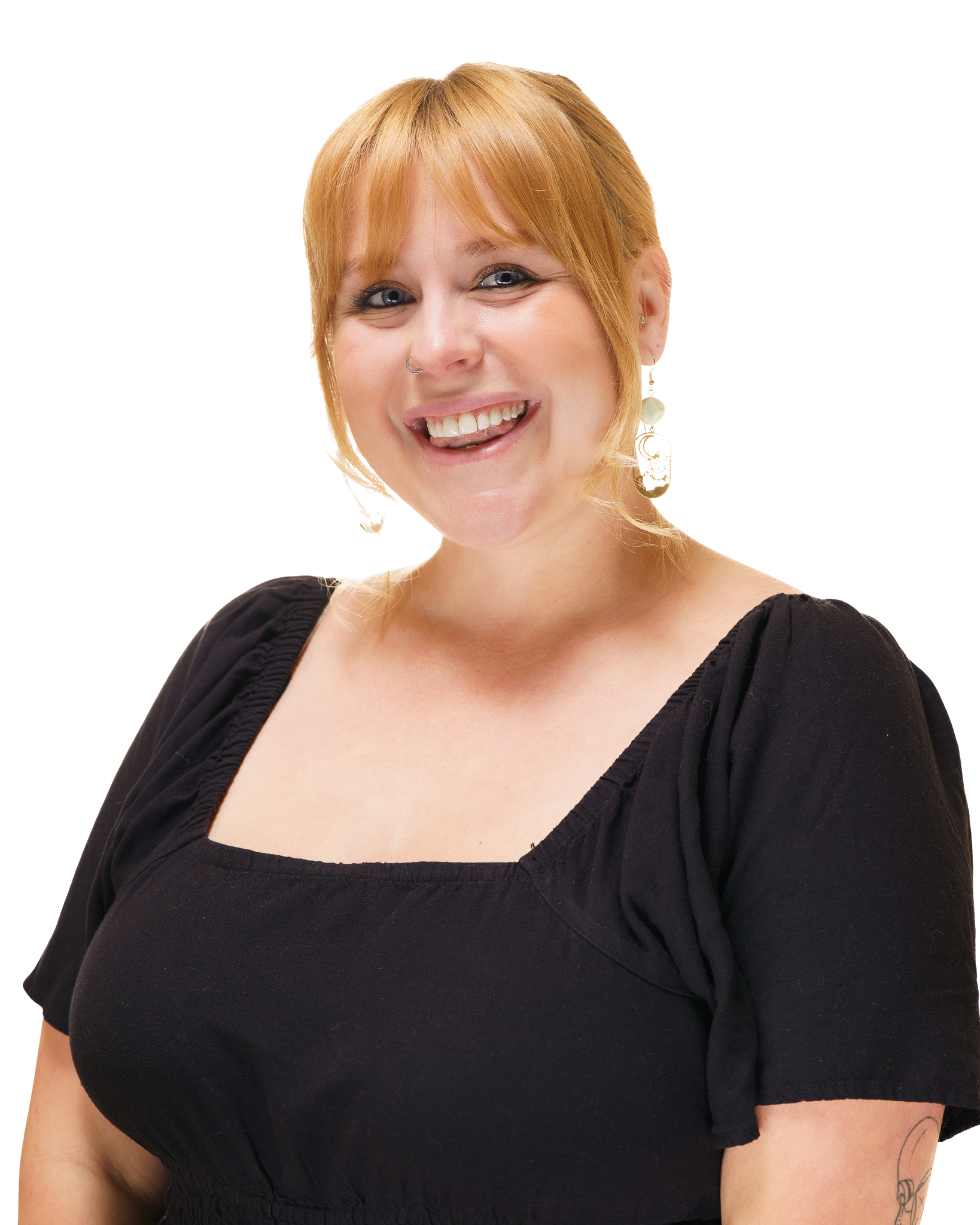 A woman with short blonde hair smiling and showing her teeth, wearing a black top.