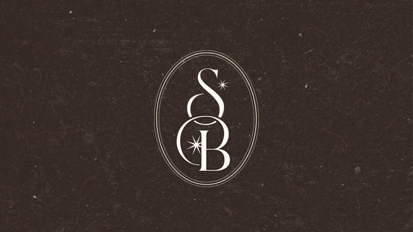 A logo with stylized initials 'S', 'C', and 'B' inside an oval frame, set against a textured dark background.