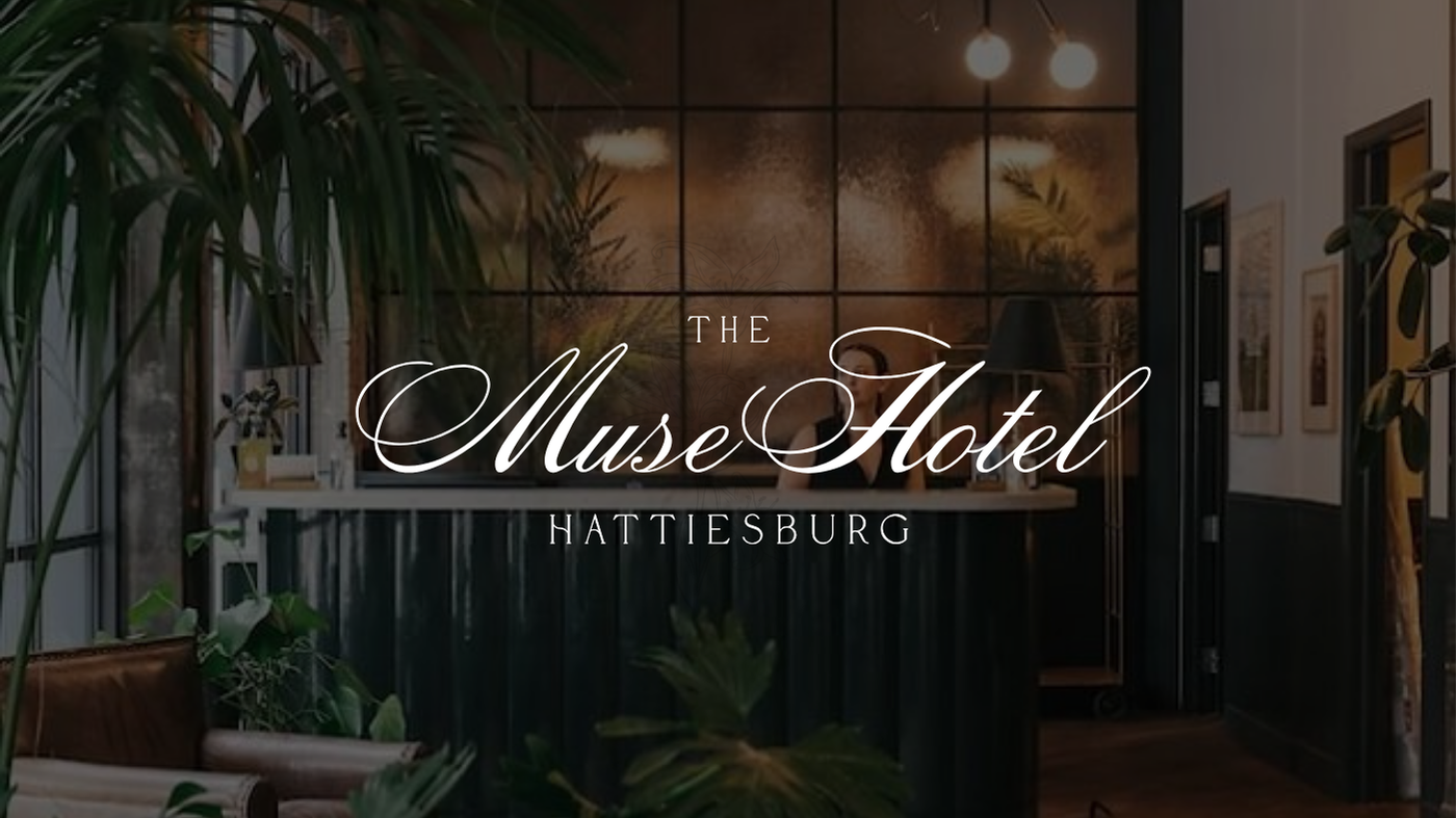 The Muse Hotel in Hattiesburg logo with lush green plants, warm lighting, and wall art background