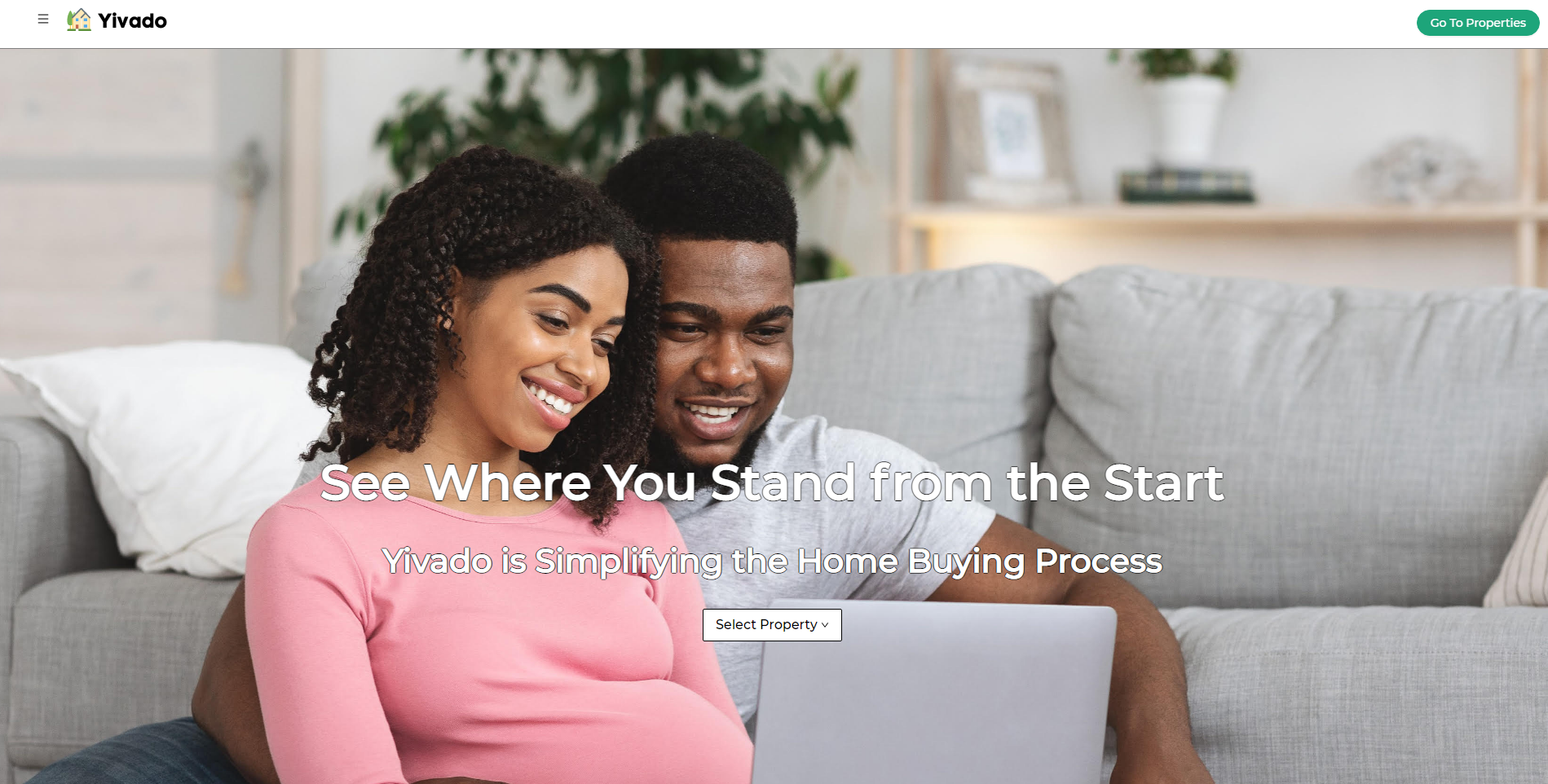 A smiling woman and man sitting on a couch looking at a laptop, with a living room background, promoting Yivado's home buying process.