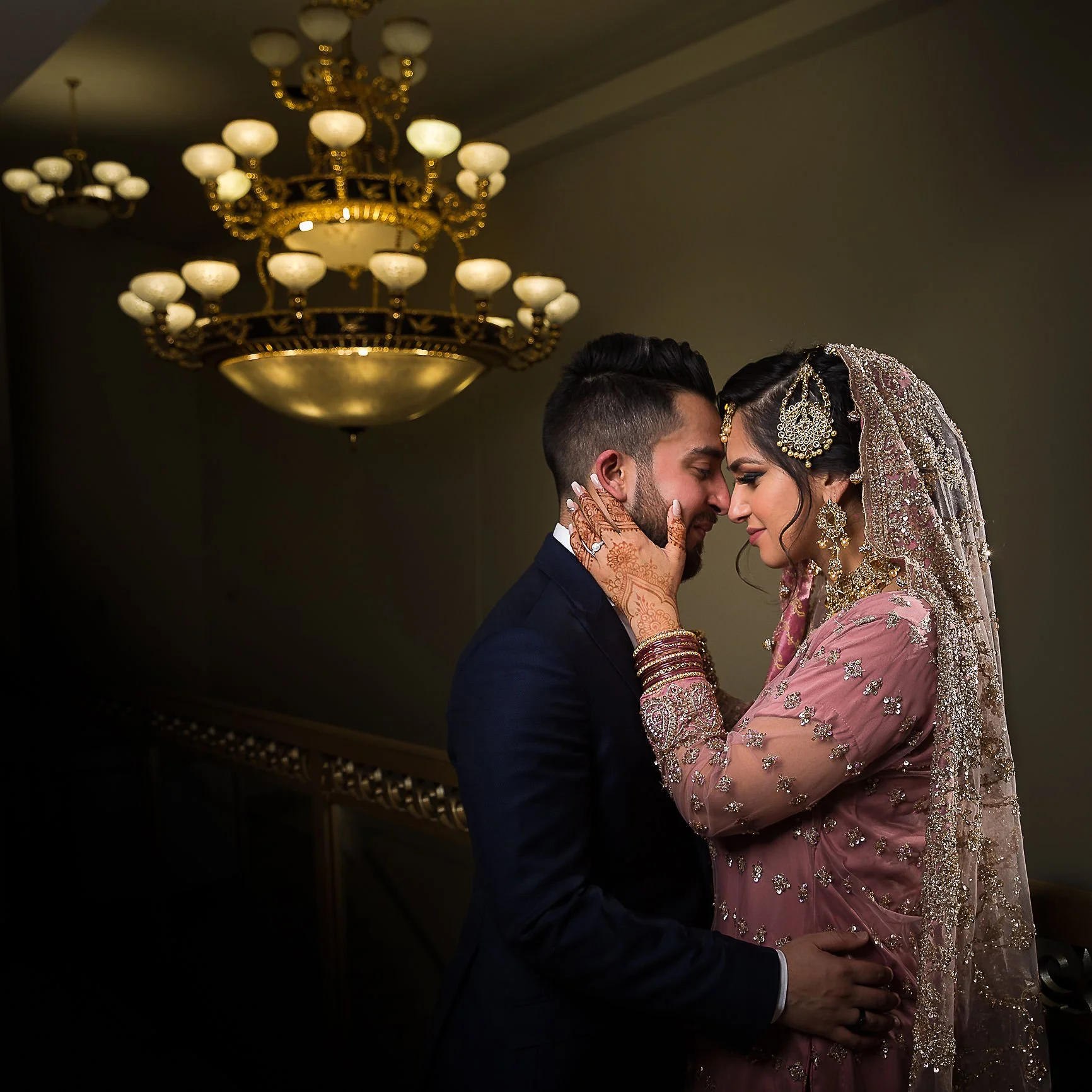 Distant mountain range with calm water in foreground and a building corner, silhouetted trees.