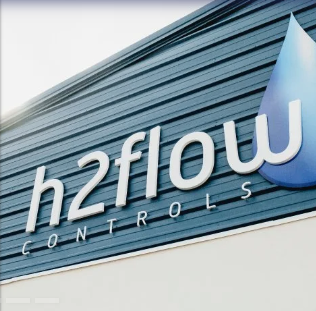 Sign for hashflow controls on the side of a building, featuring a blue water droplet logo.
