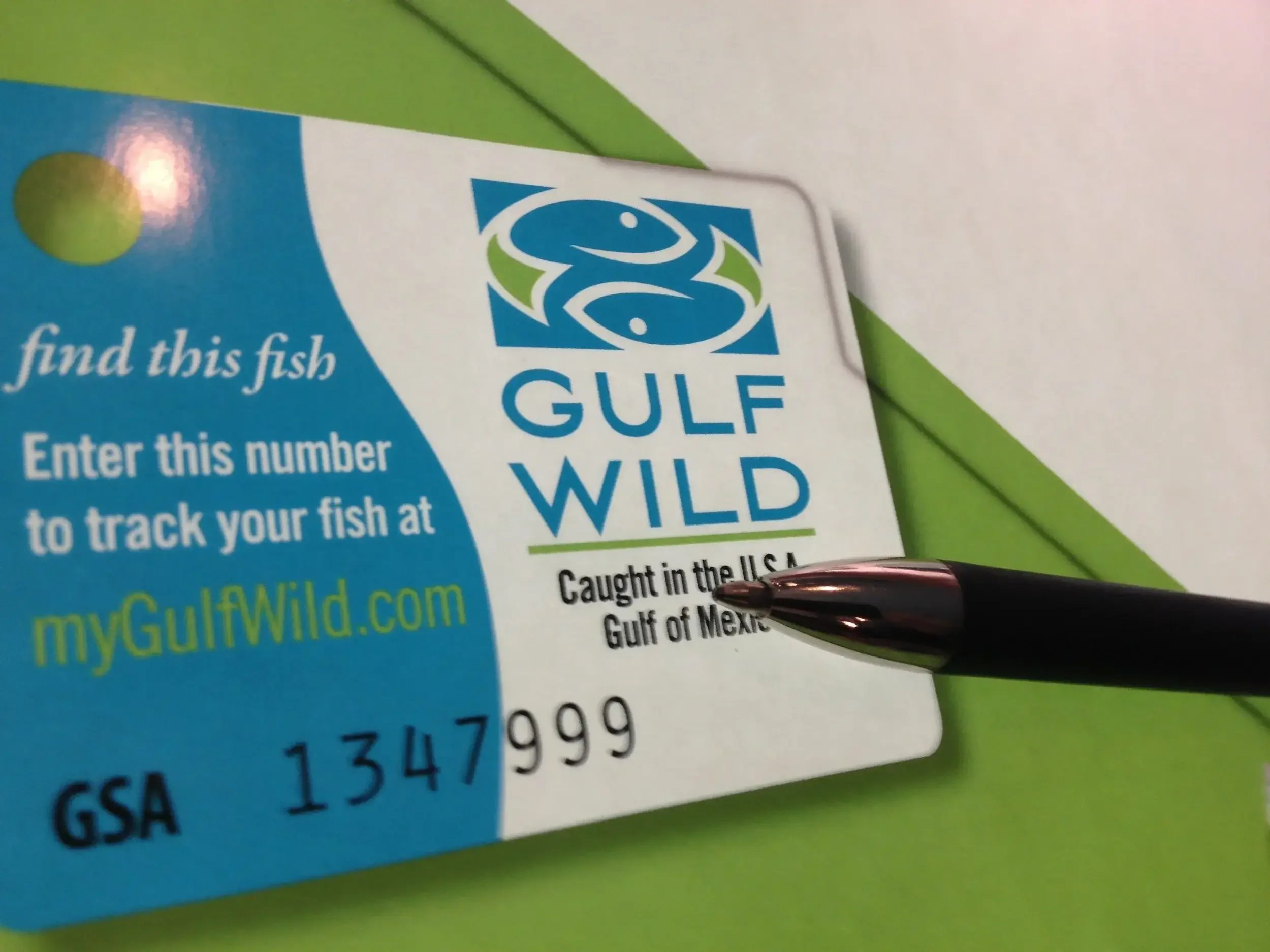 Gulf Wild fishing tag with a pointing black pen, indicating it's caught in the Gulf of Mexico.