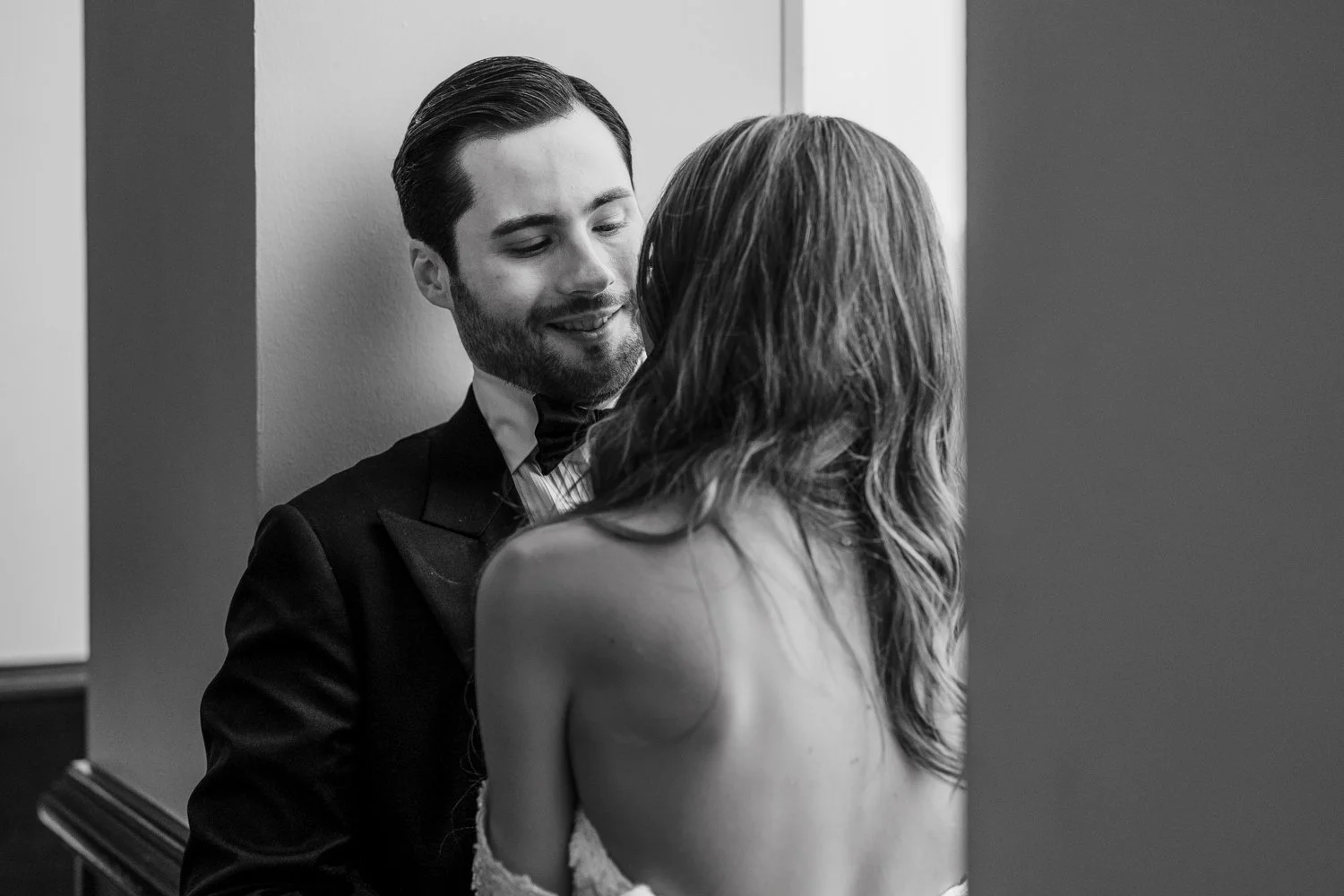 Black and white documentary-style wedding portrait of the bride and groom sharing an intimate moment inside Plaza Antique Montreal.