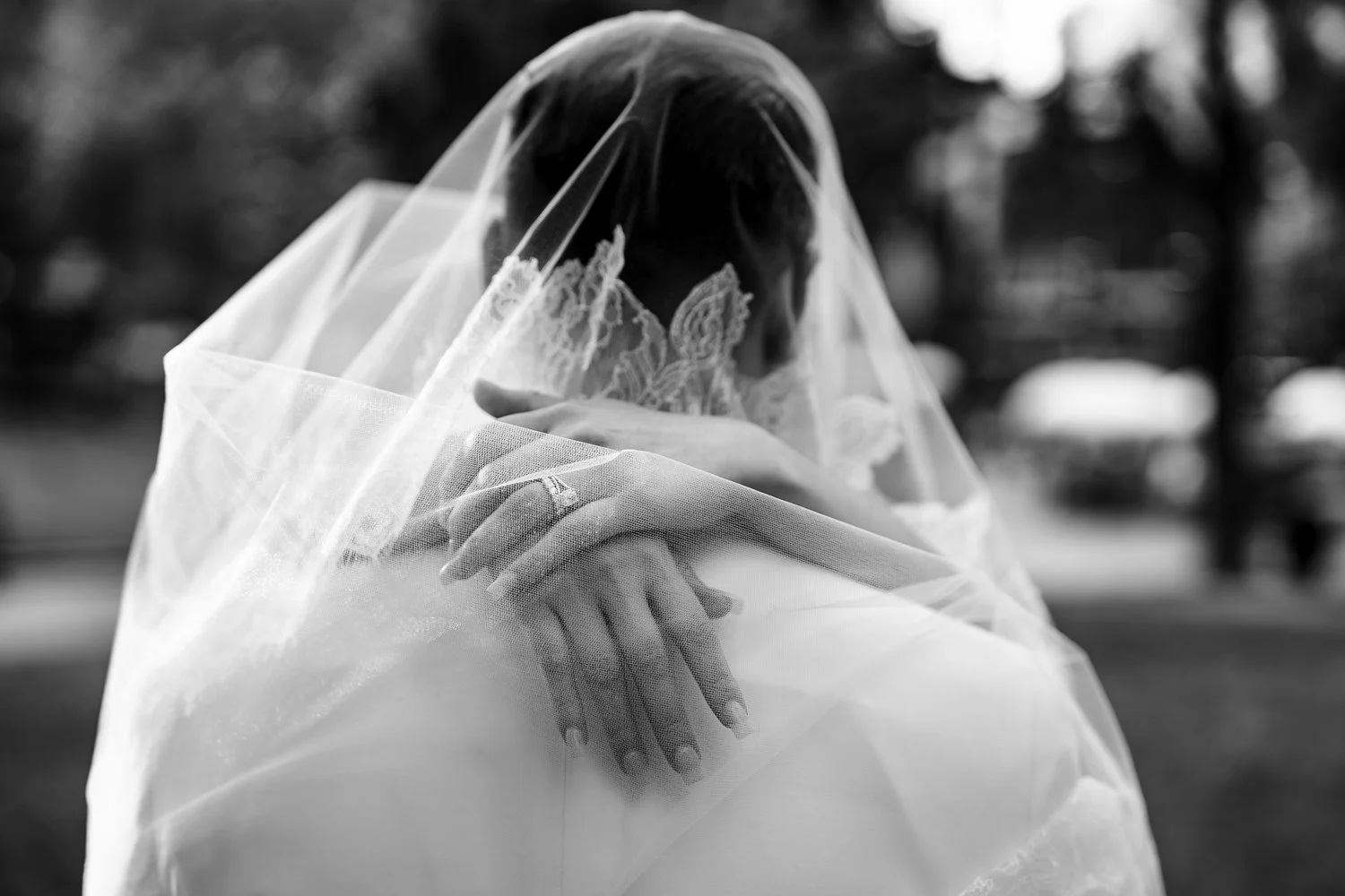 Romantic black-and-white portrait of a newlywed couple embracing beneath the bride's veil during a Montreal wedding