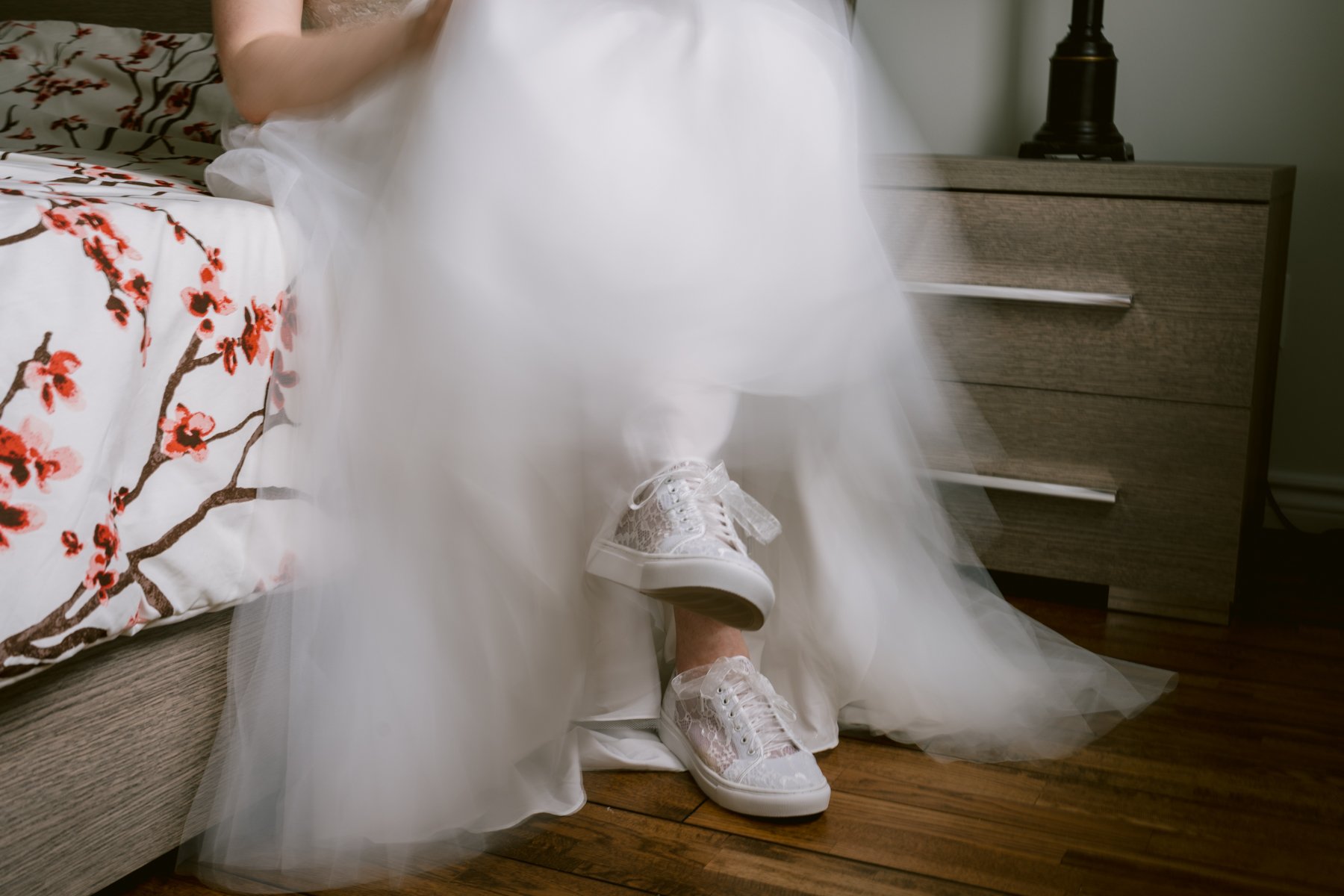 Bride wearing white sneakers with her wedding dress