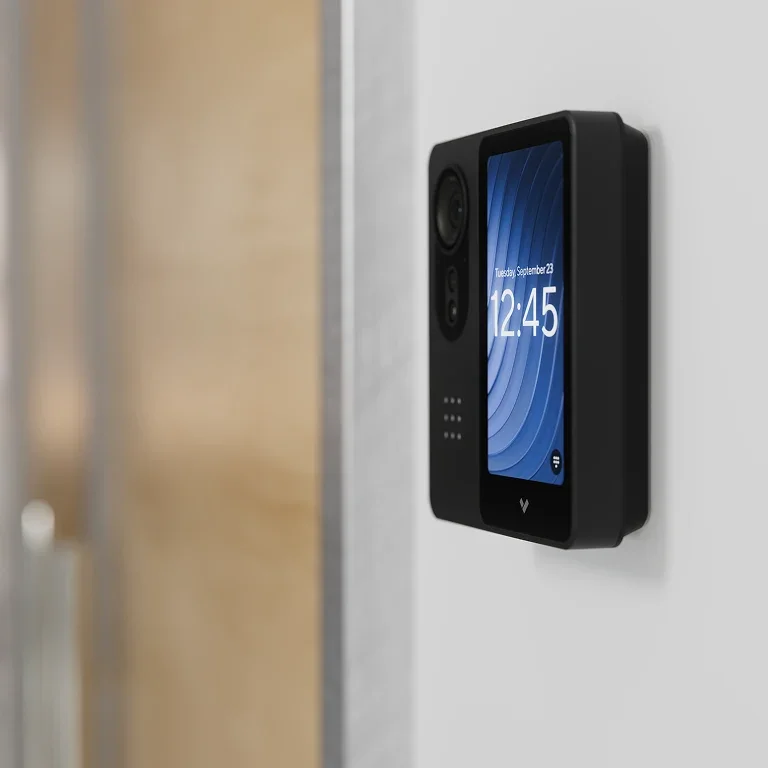 Digital door access controller mounted on wall beside a door, showing the date and time on its screen.