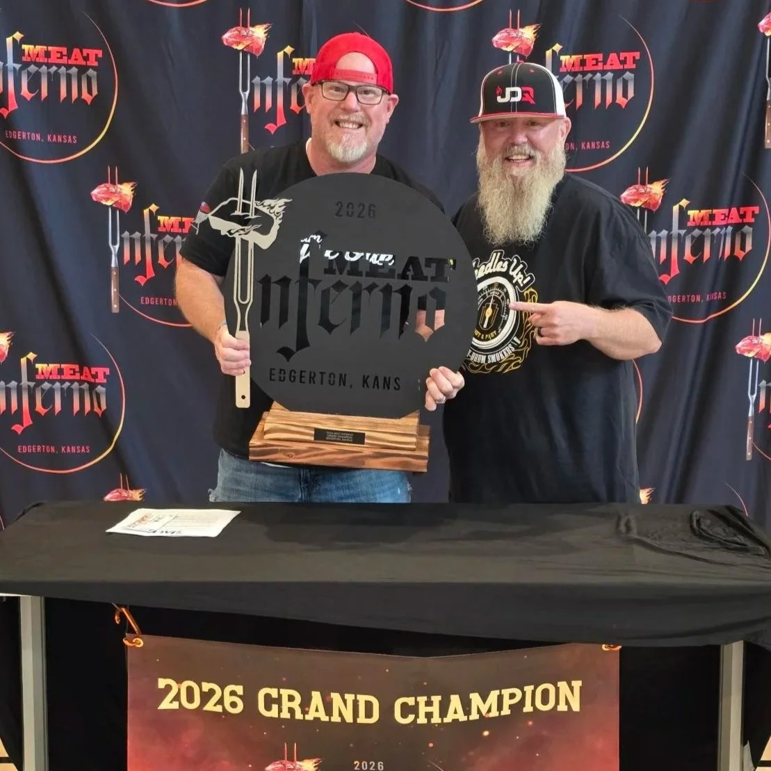 2026 Grand Champion - JDQ BBQ. The cooks smile while holding the Meat Inferno trophy