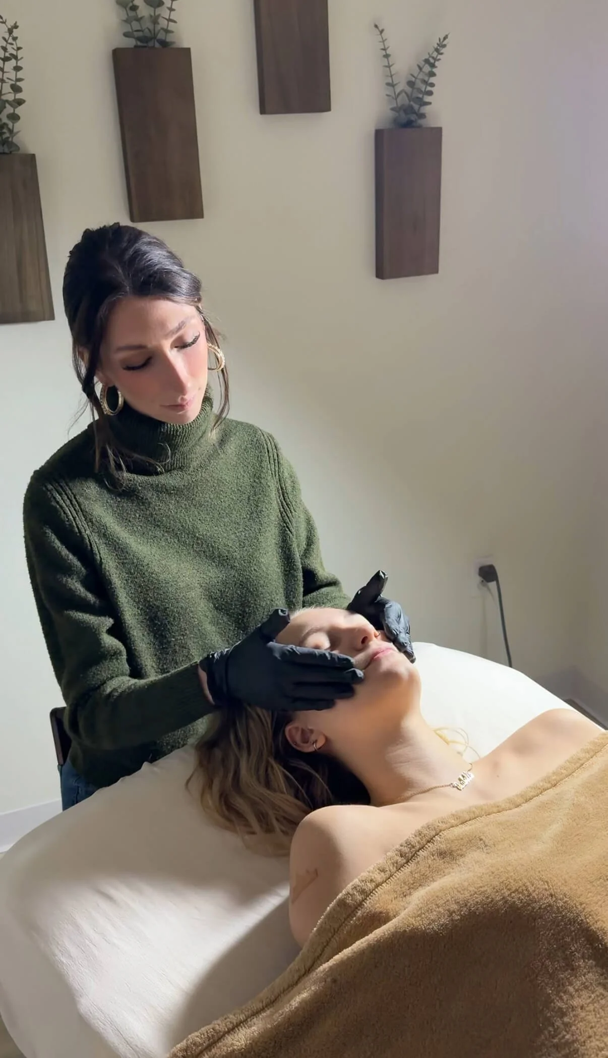 Esthetician doing facial at Salt + Light Salon and Spa in Cincinnati, Ohio