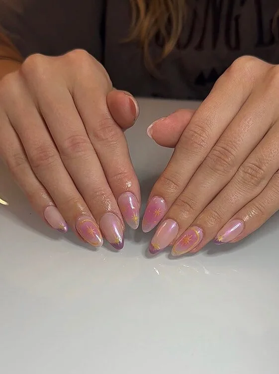 Custom nail design featuring iridescent pink polish and yellow sunburst designs done at Salt + Light Salon and Spa in Cincinnati, OH