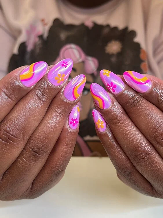 Custom nail design with colorful floral and swirl nail art, featuring pink, yellow, and purple swirls with flower accents done at Salt + Light Salon and Spa in Cincinnati, OH