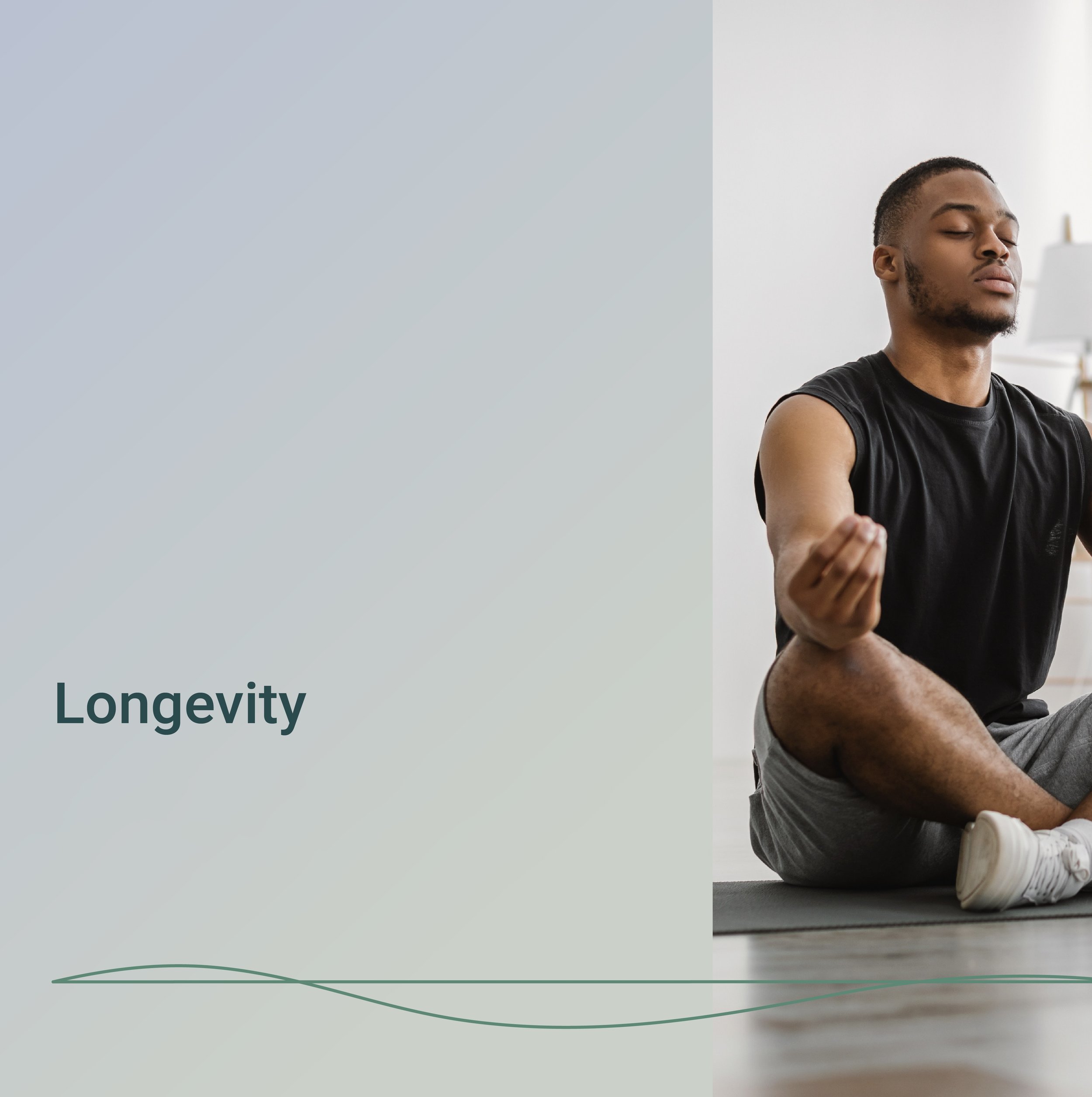 A young man is sitting cross-legged on the floor with his eyes closed, meditating or practicing mindfulness in a well-lit room.