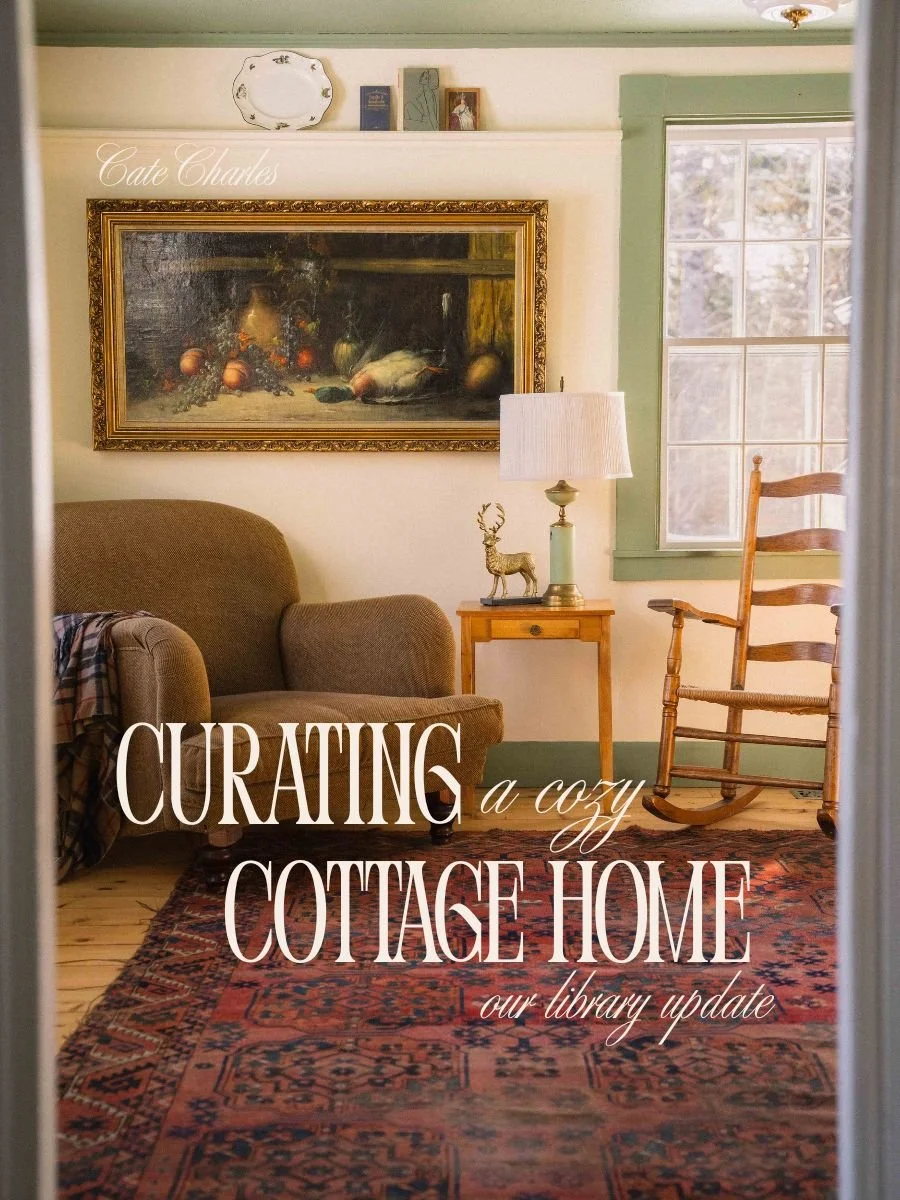 image is of a english style roll arm chair in a cream room with green trim in a cottage style design, with a ladder back rocking chair, side table with scalloped lamp, and still life oil painting text reads "curating a cozy cottage home: our library"