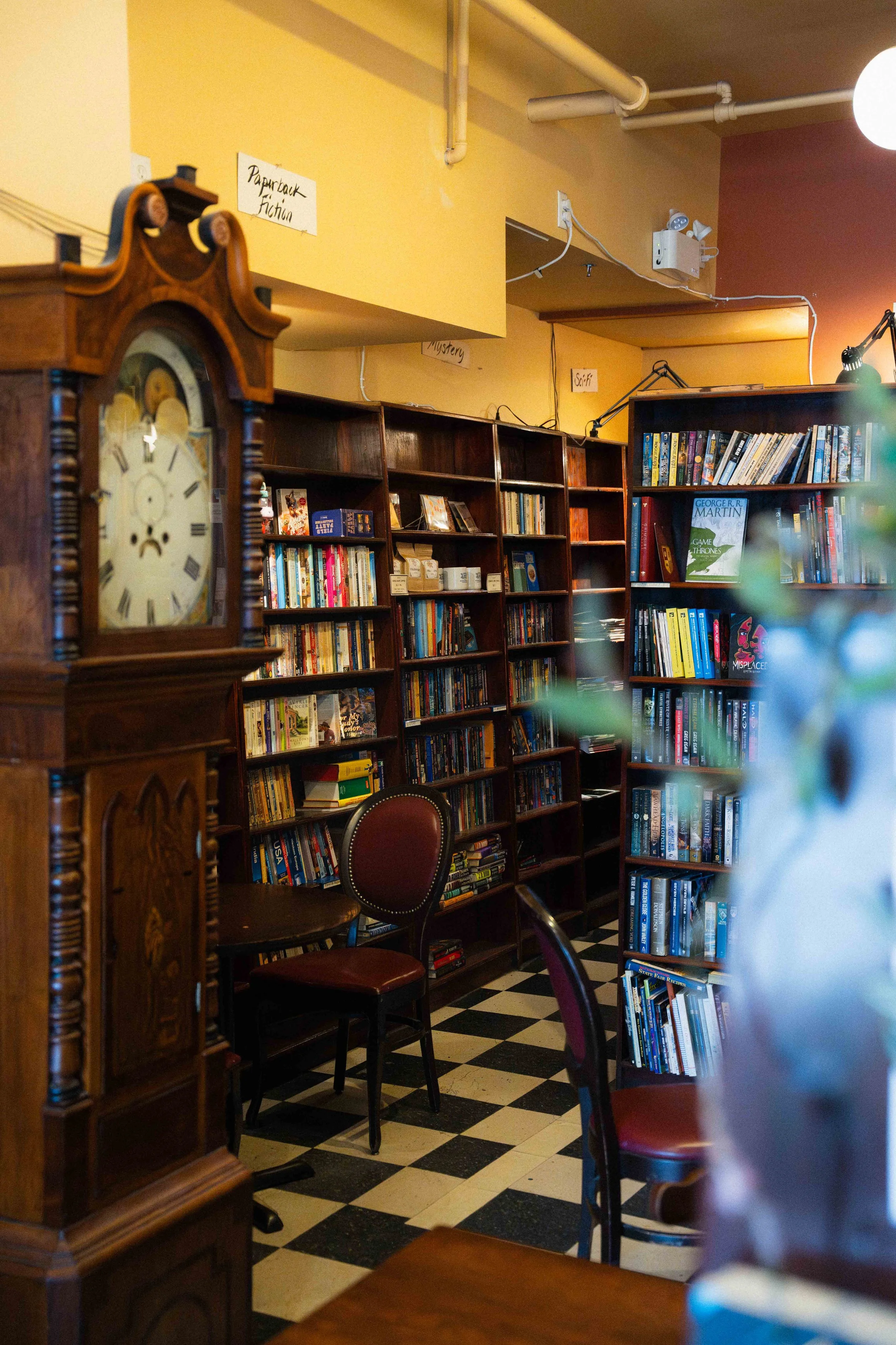 inside a local bookstore in downtown Halifax, Nova Scotia, Canada; a cozy space with walls lined with books and an antique grandfather clock