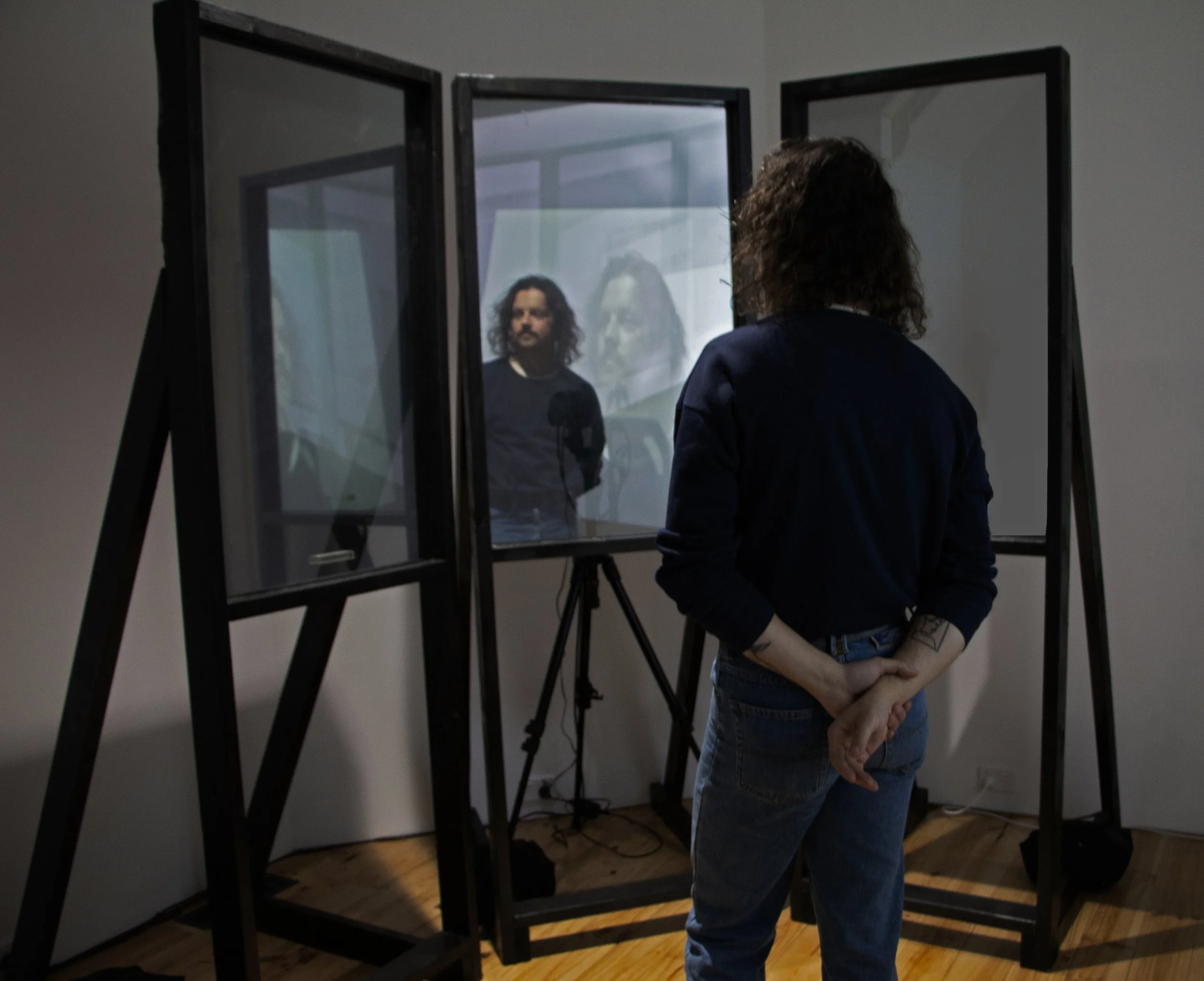 'In Frame', pinewood, glass panels, two-way mirrored film, livestream camera, pre-recorded video, projection, 'INT.',  Green Floor Gallery, 2024