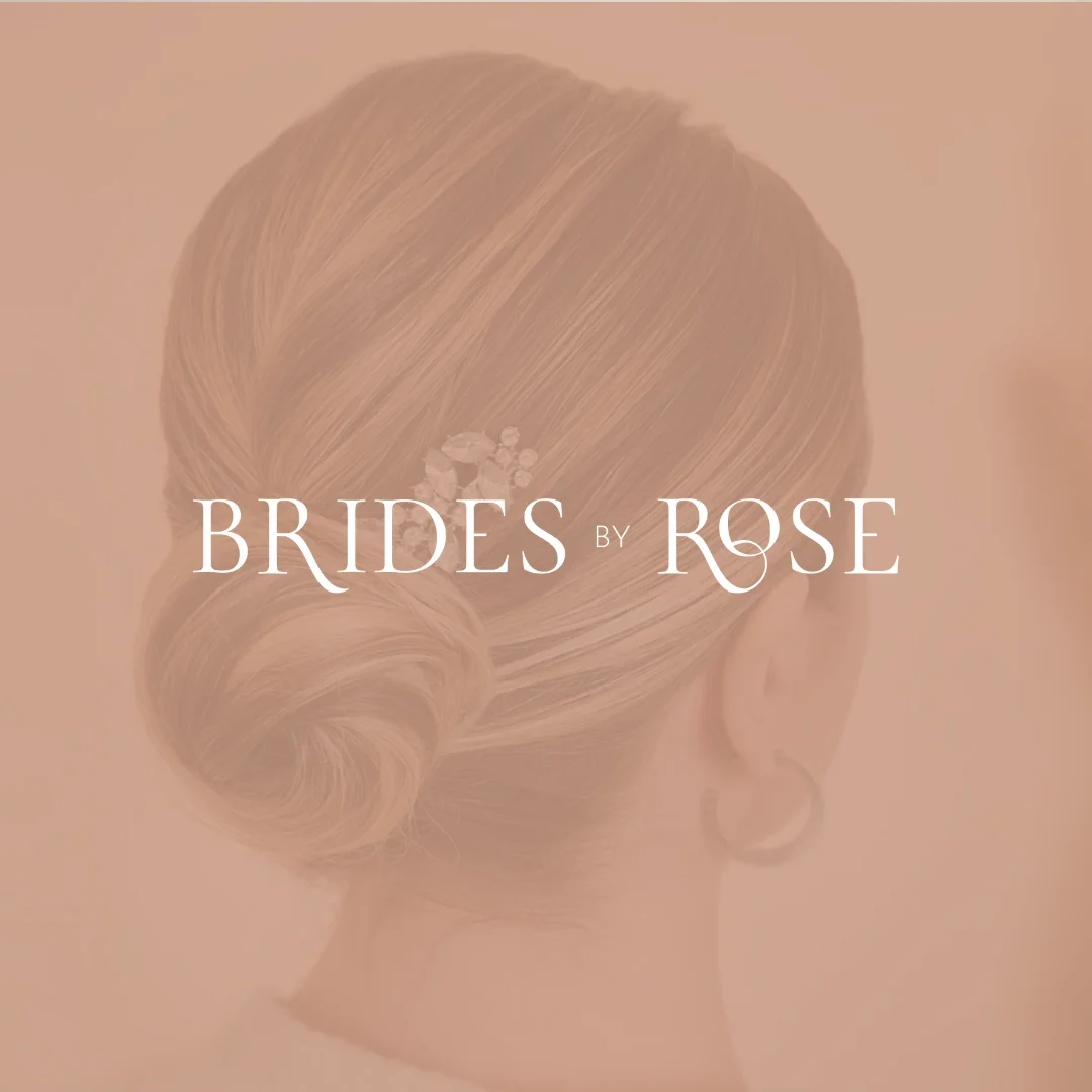 Back of a woman's head with an elegant low bun hairstyle and a decorative hairpin. Overlay text: Brides by Rose.