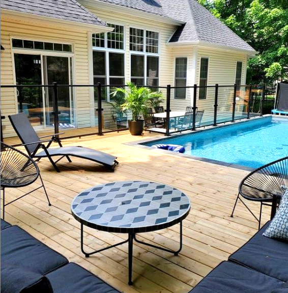 Multi-level deck around an above ground pool, giving it an in ground feeling.