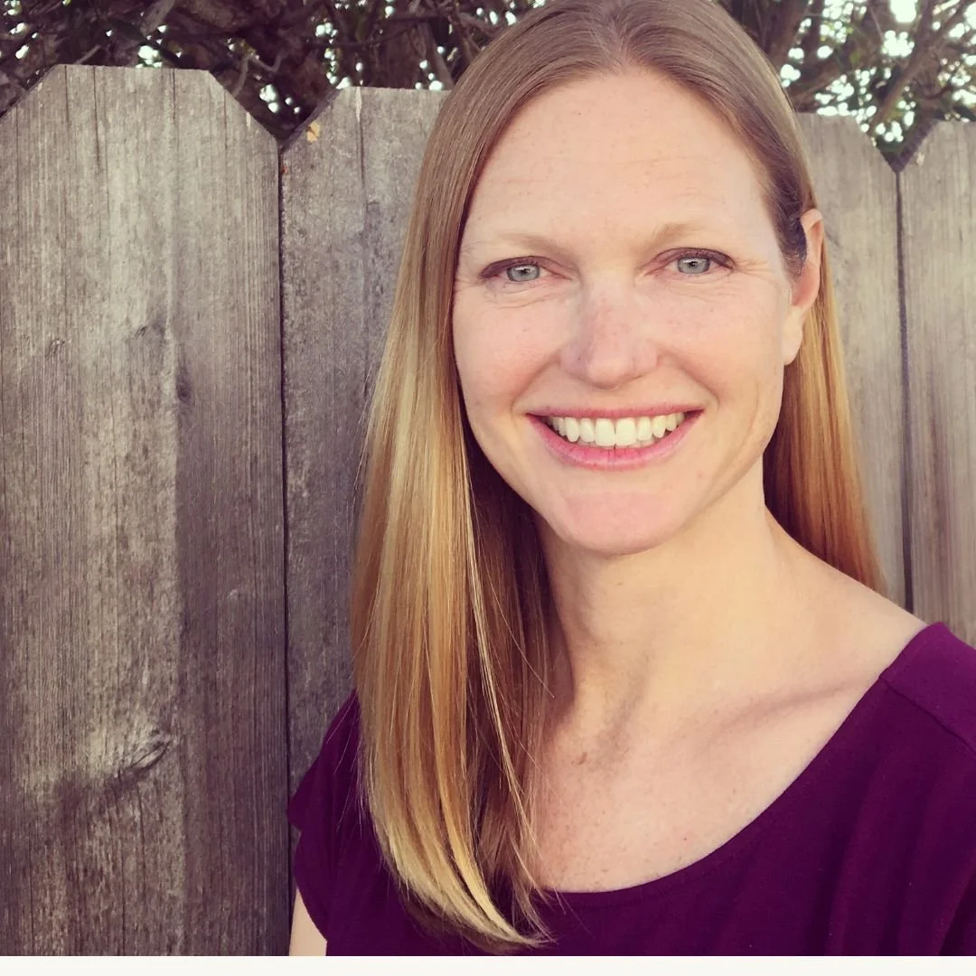 image of a woman with kind eyes and a warm smile standing in front of a fence. Lauren Fox, therapist Palm Desert