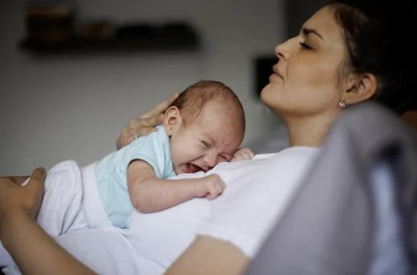 image of a postpartum mom and her crying newborn baby.