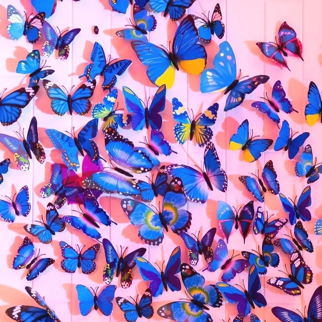 Dozens of blue butterflies on a pink wood fence