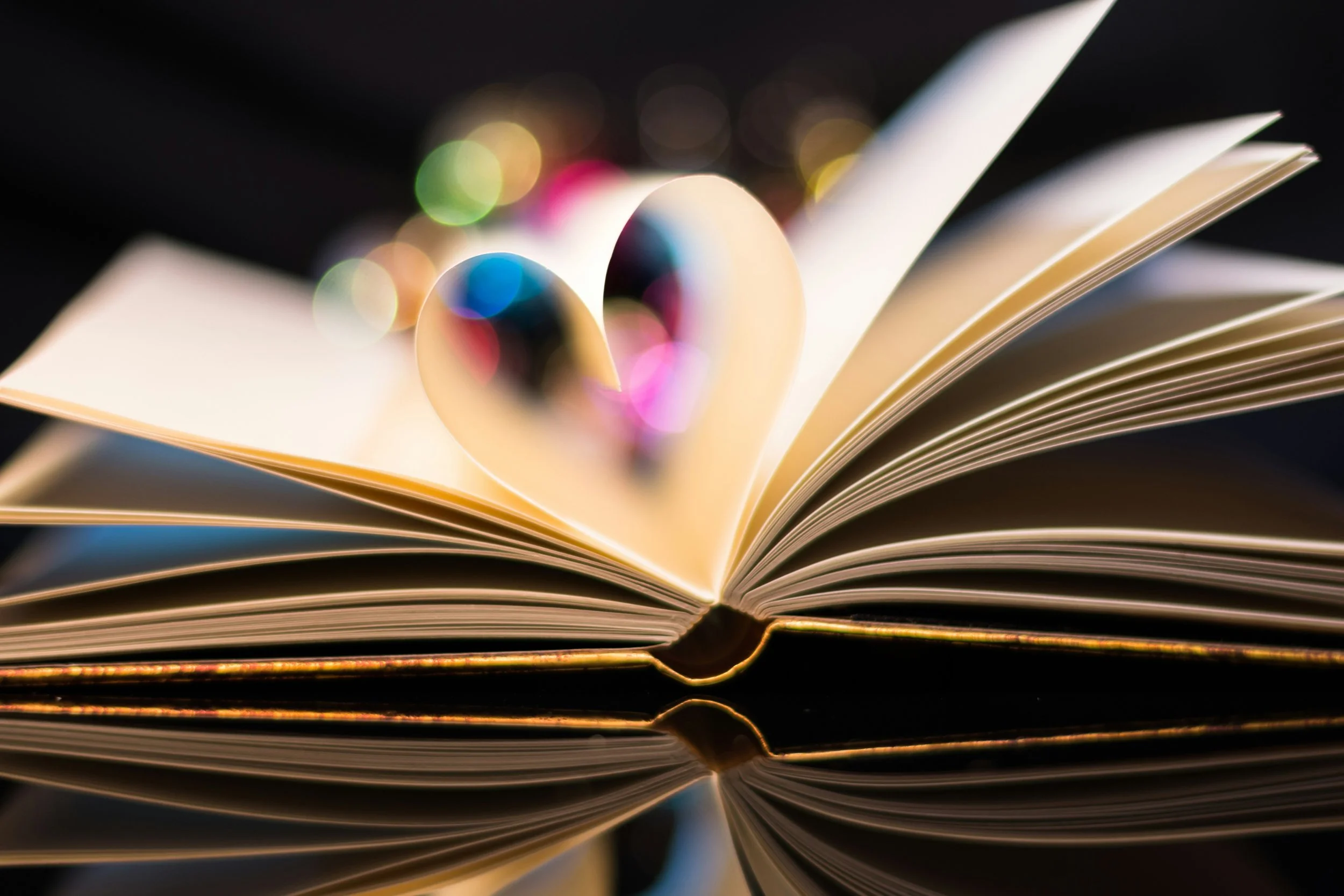 An open book with pages folded into a heart shape