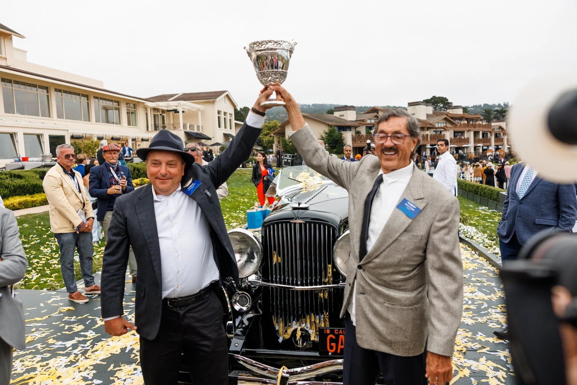 Harry Yeaggy and Chris Charlton holding up trophy at Pebble Beach Concours d'Elegance