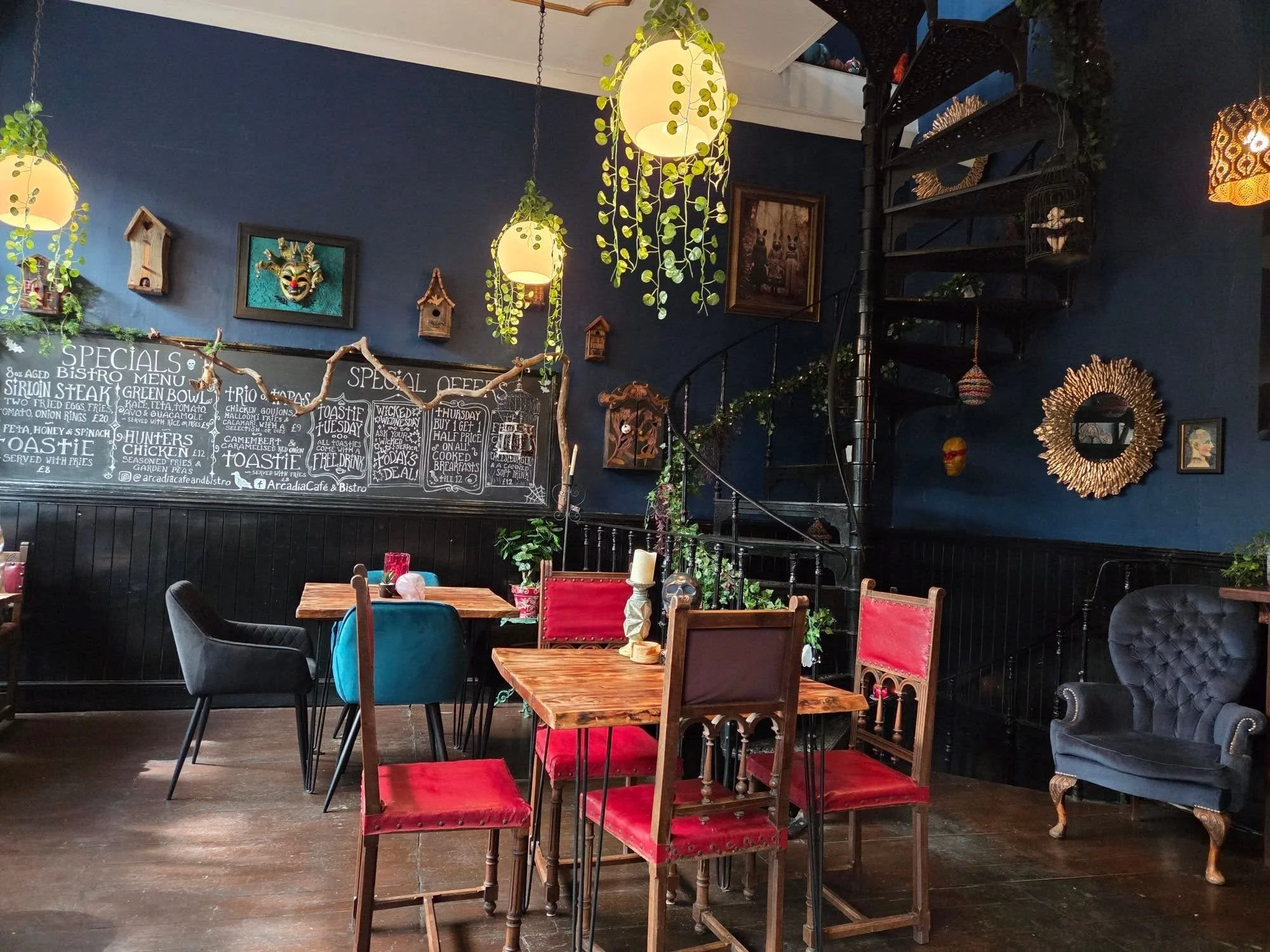 A dining area painted in navy with natural looking plant lighting and a Gothic theme