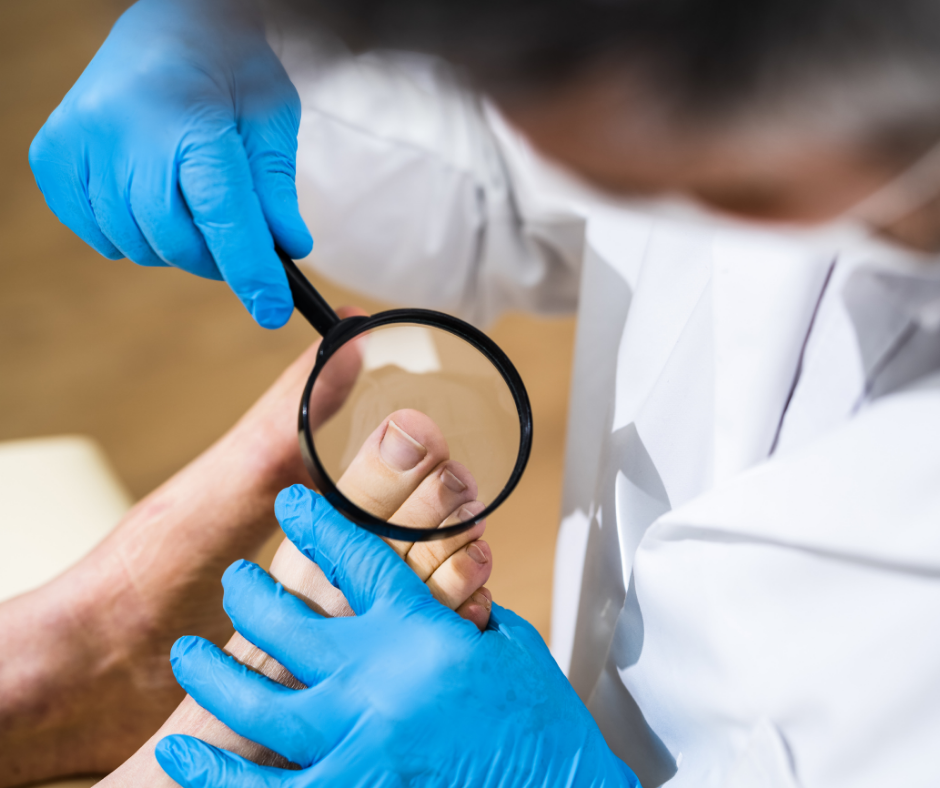 Healthcare professional wearing blue gloves examining a patient's foot with a magnifying glass.