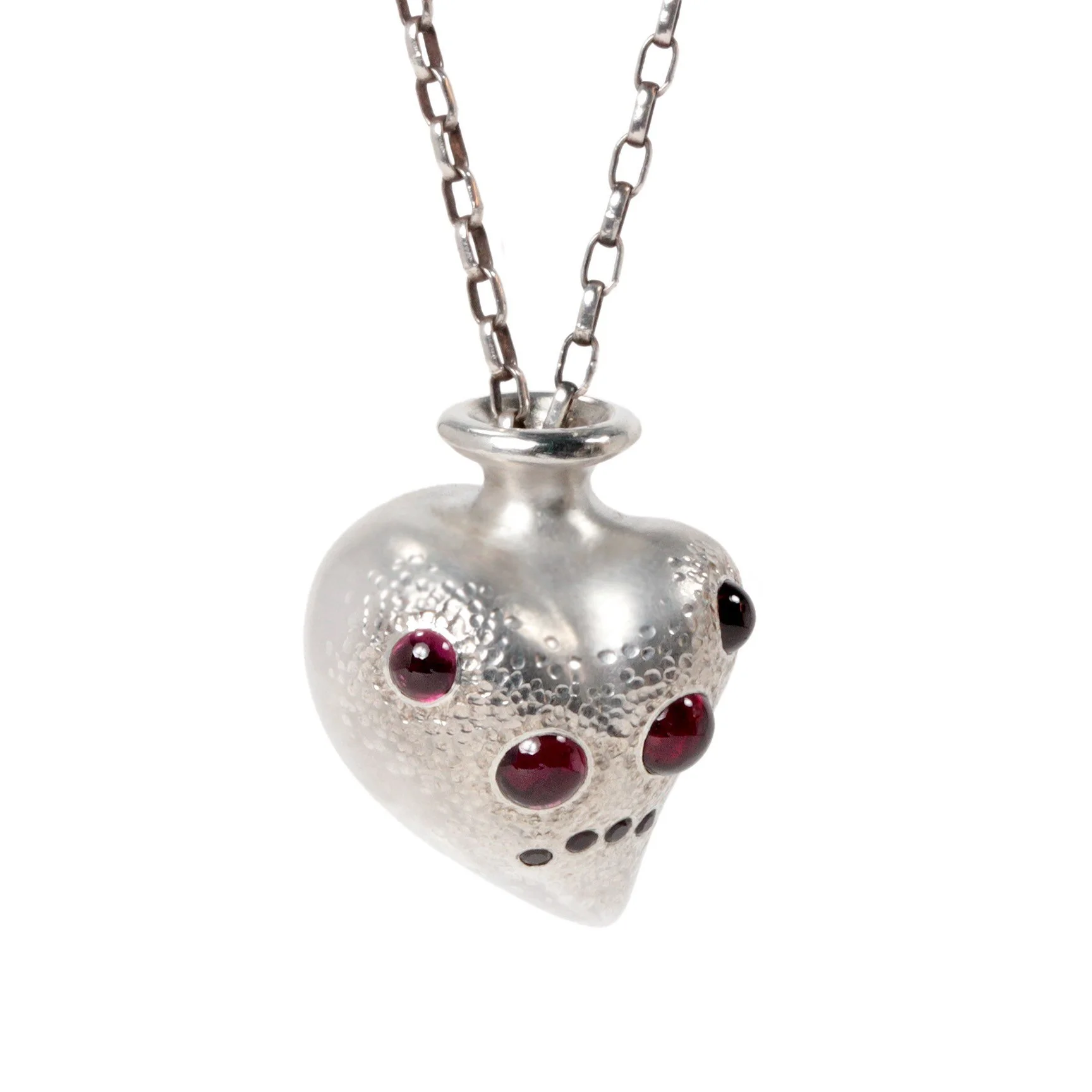 A heart shaped pendant with garnets set in teh arrangement of sipder eyes