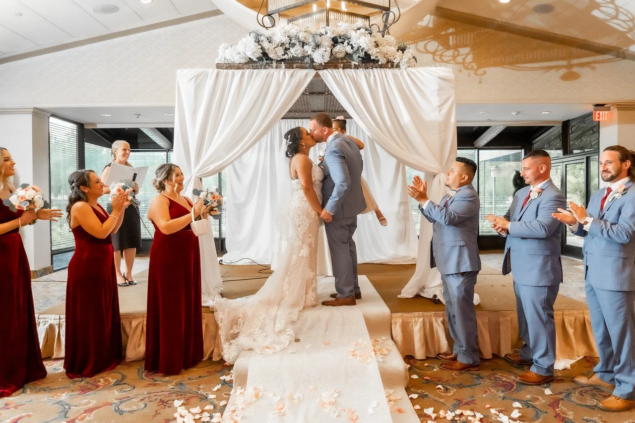 bride and groom kissing at altar