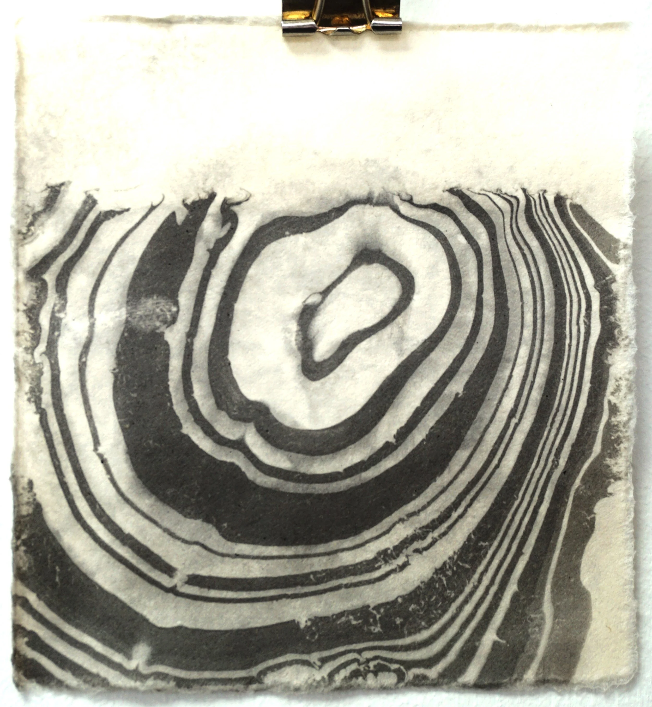 Black and white topographic map with concentric contours forming a spiral pattern.