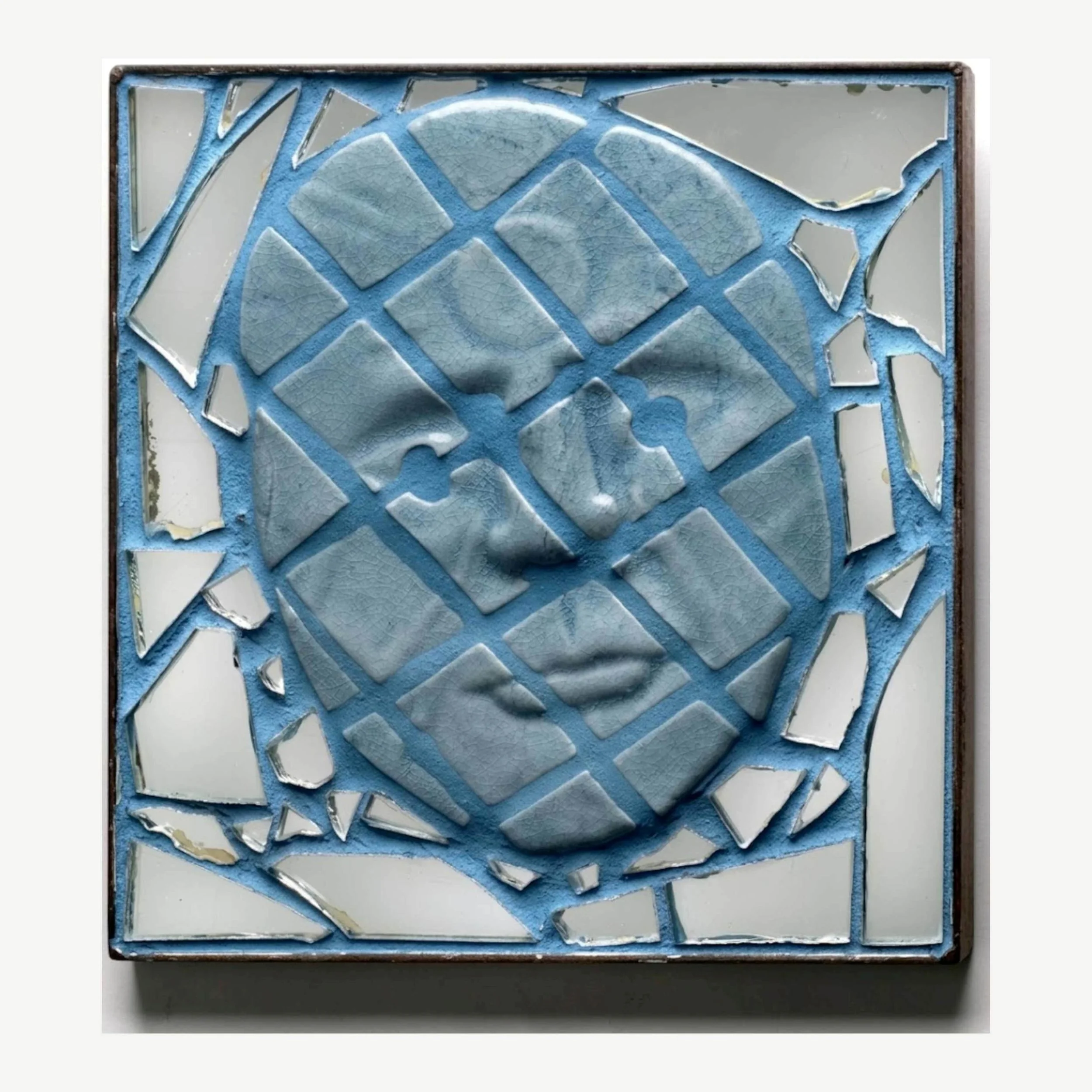 An mosaic of an abstract blue human face, cross sectioned and surrounded by broken pieces of glass.