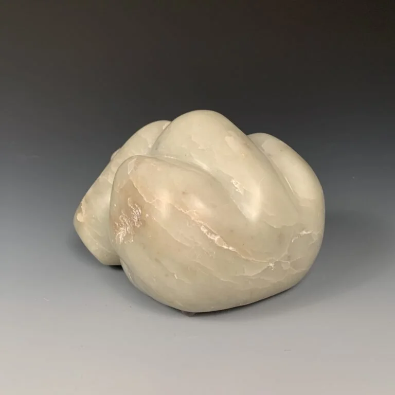 Full rear view of a bear lying down, hardmade from green soapstone