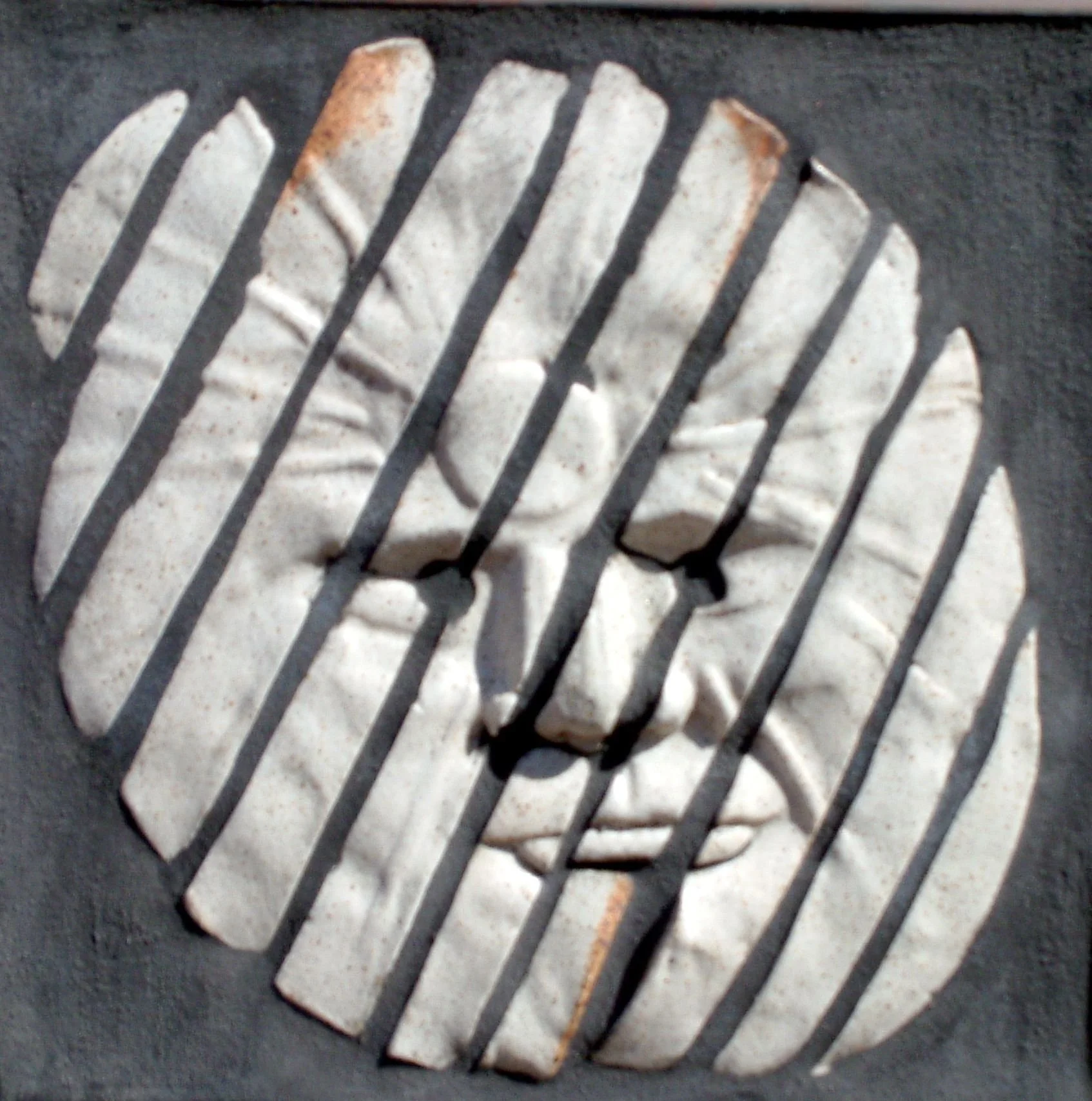 mosaic of a man's face in tile strips  on a grey background