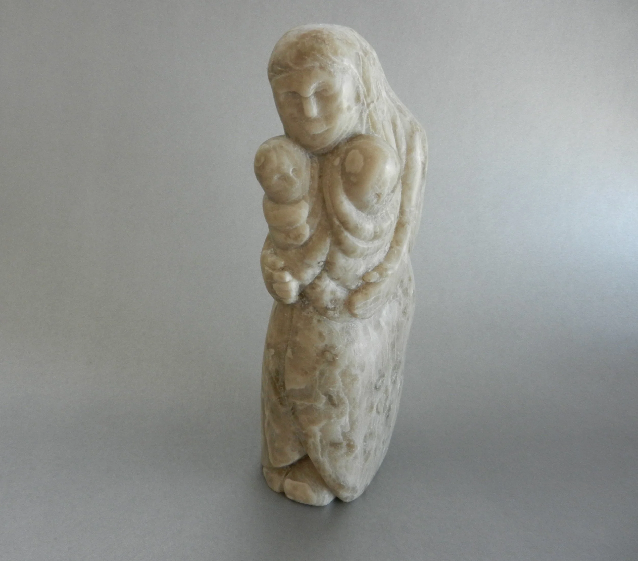 Alabaster figurine of a woman holding twins.