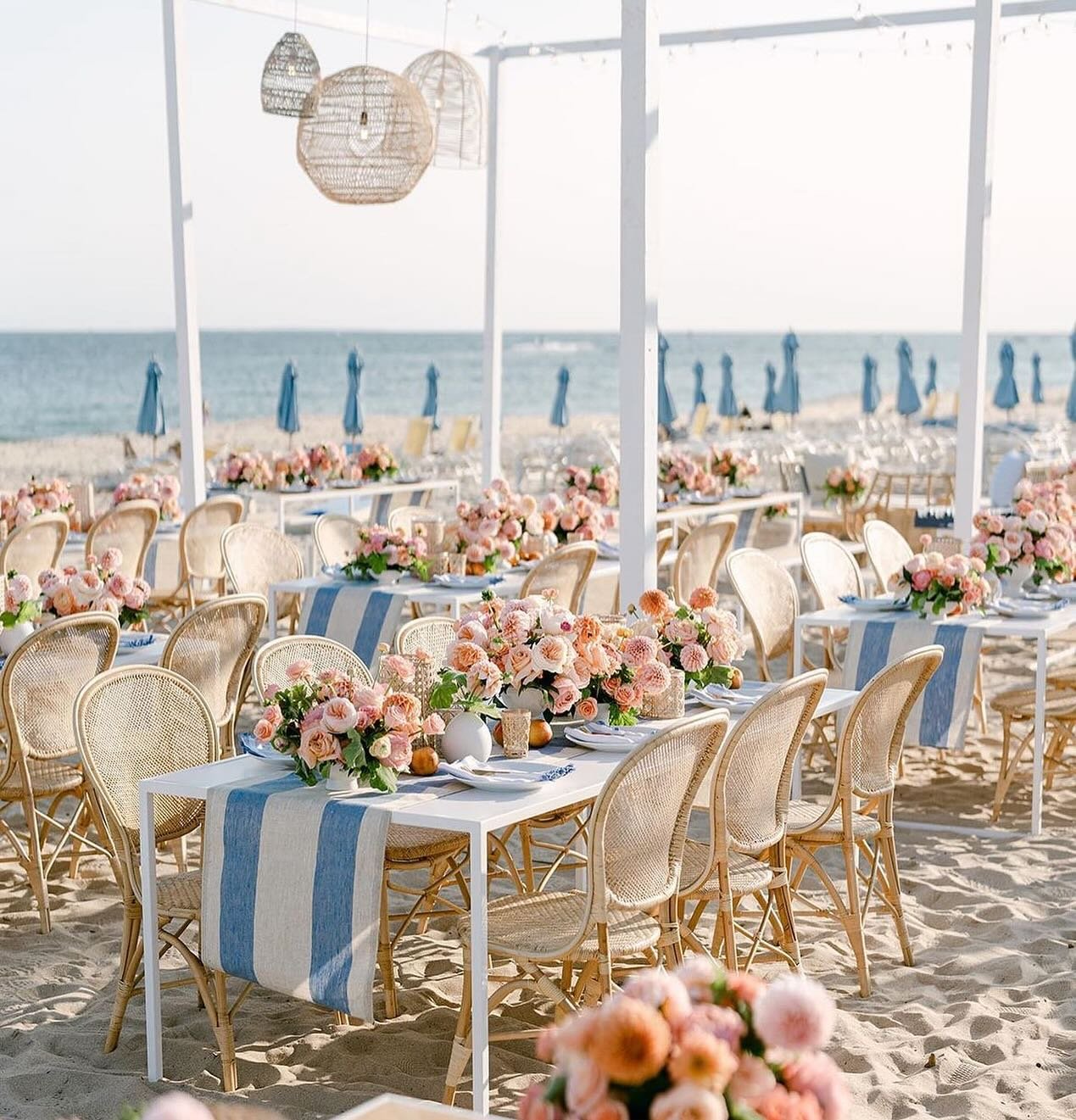 A quintessential New England soir&eacute;e at @oceanhouseri - Picture soft sands, the gentle sound of waves, and a warm breeze carrying the scent of peach, pink, and coral flowers. Tables adorned with delicate blooms and seasonal fruit paired with so