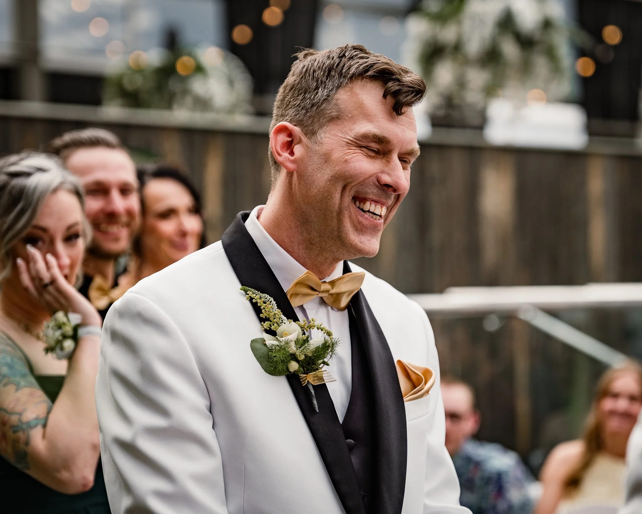 Photo of happy groom from YEG wedding with white tuxedo.