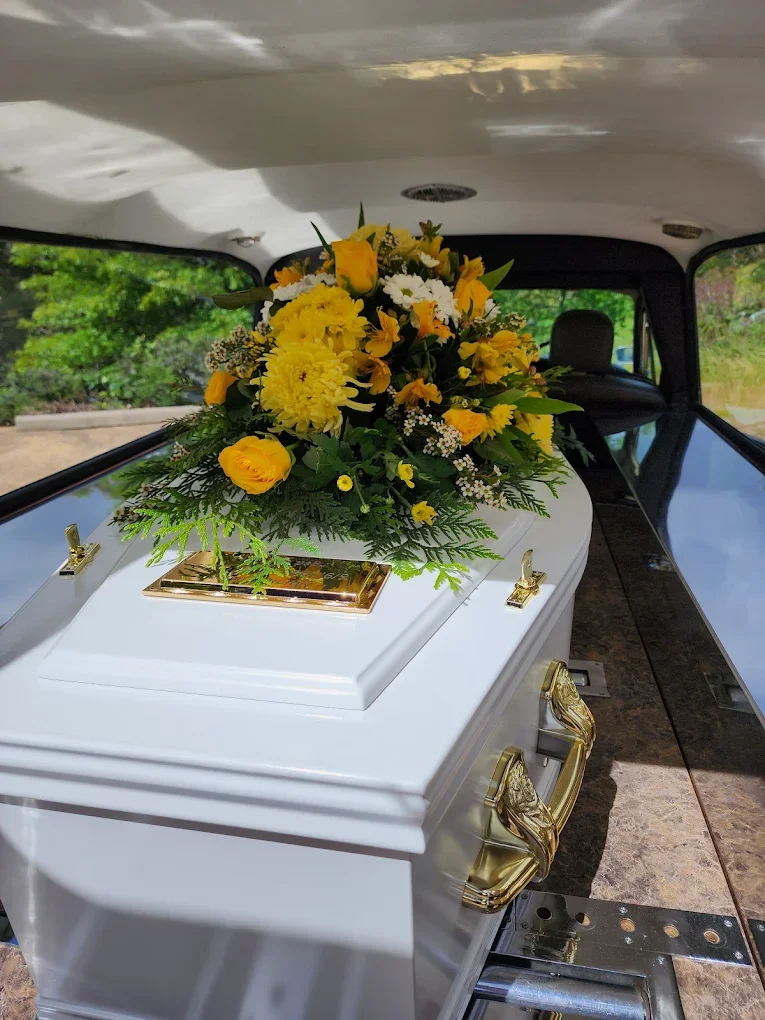 Coffin-In-Hearse-Yellow-Flowers.webp