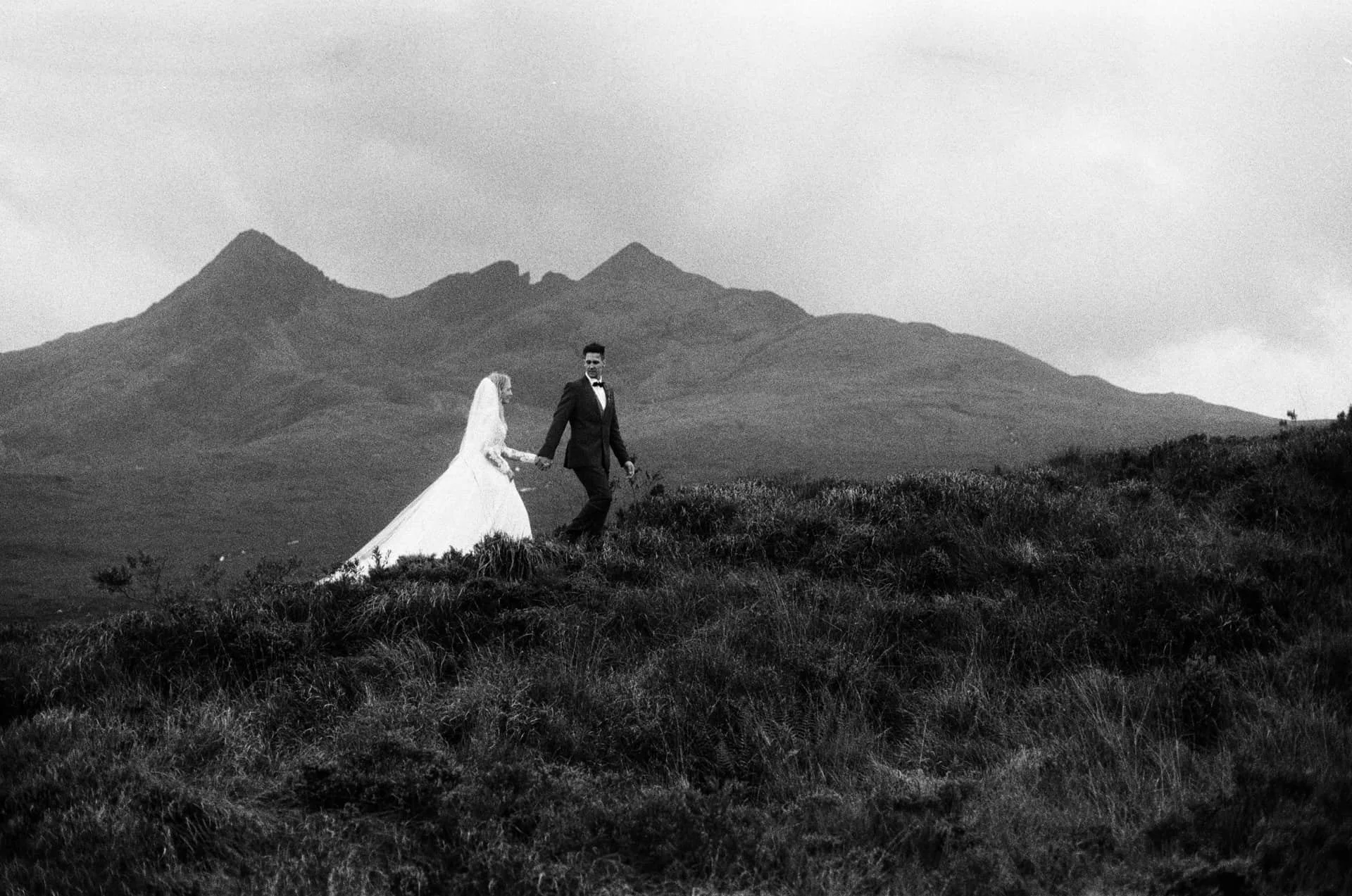 Bride and groom are on their elopement on the Isle of Skye, Scotland. Photographed by Weirdie Grizzly on 35mm Black and White film