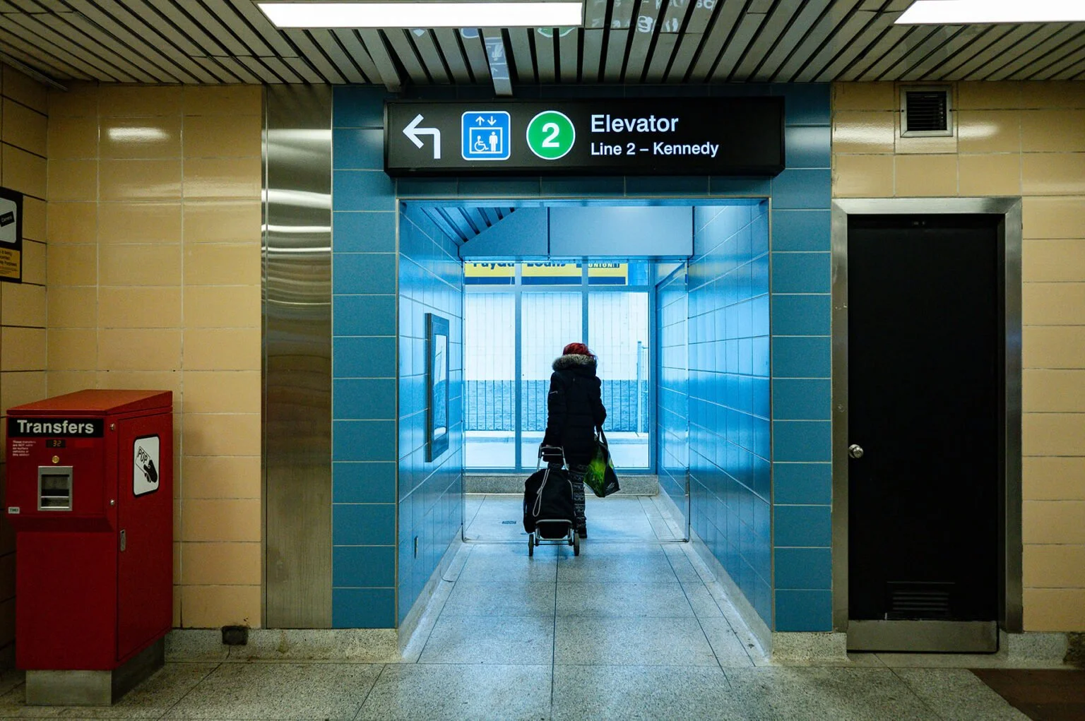 Image of a woman with grocery bags exiting a subway platform